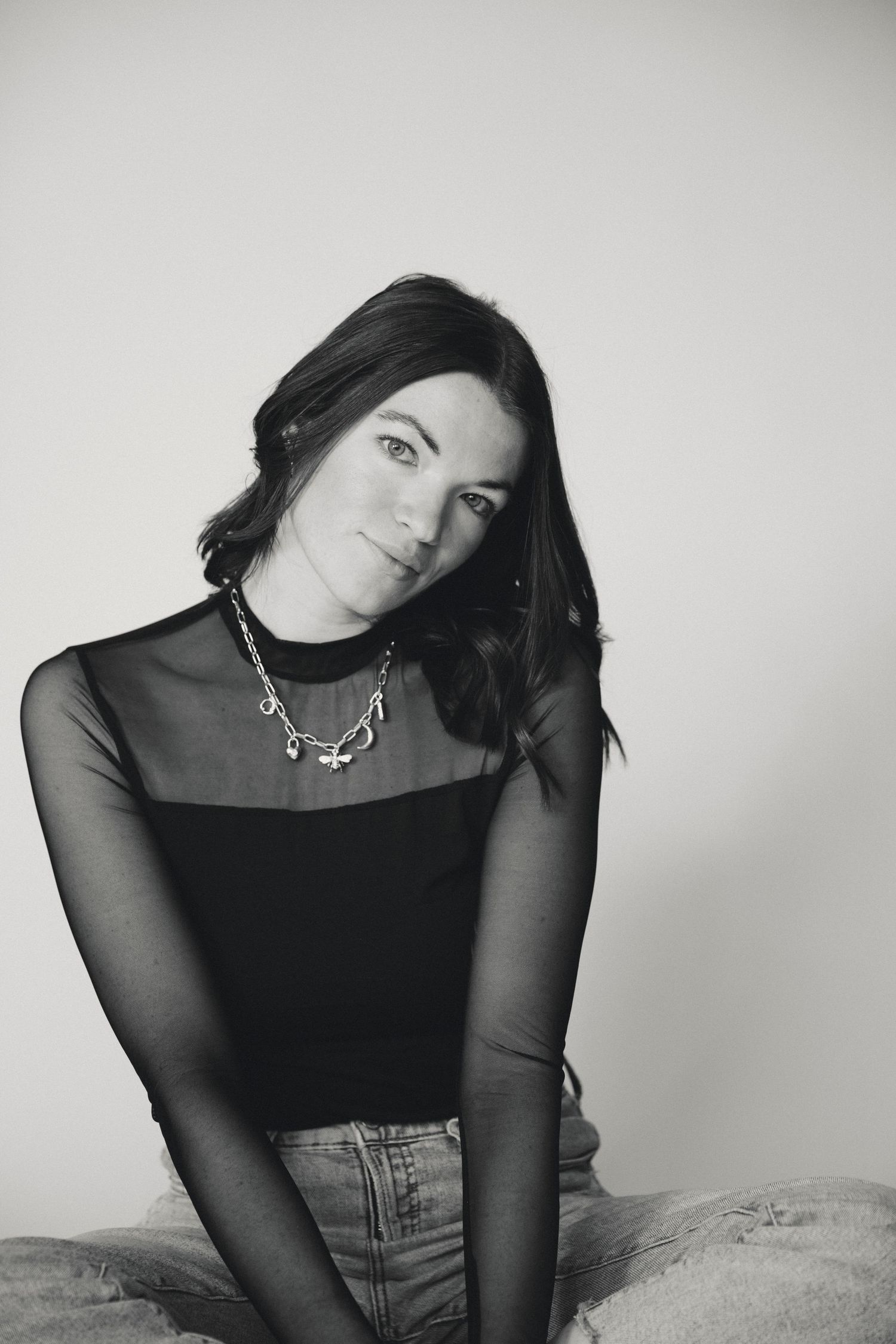 Fashion portrait series in black and white featuring sheer top and denim styling.