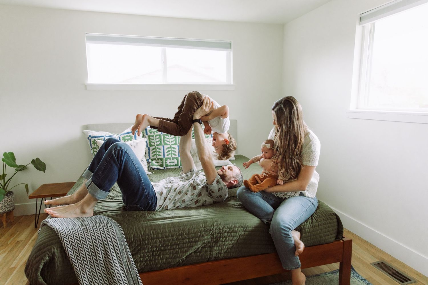 Friends relaxing and chatting on bed in bright minimalist bedroom.