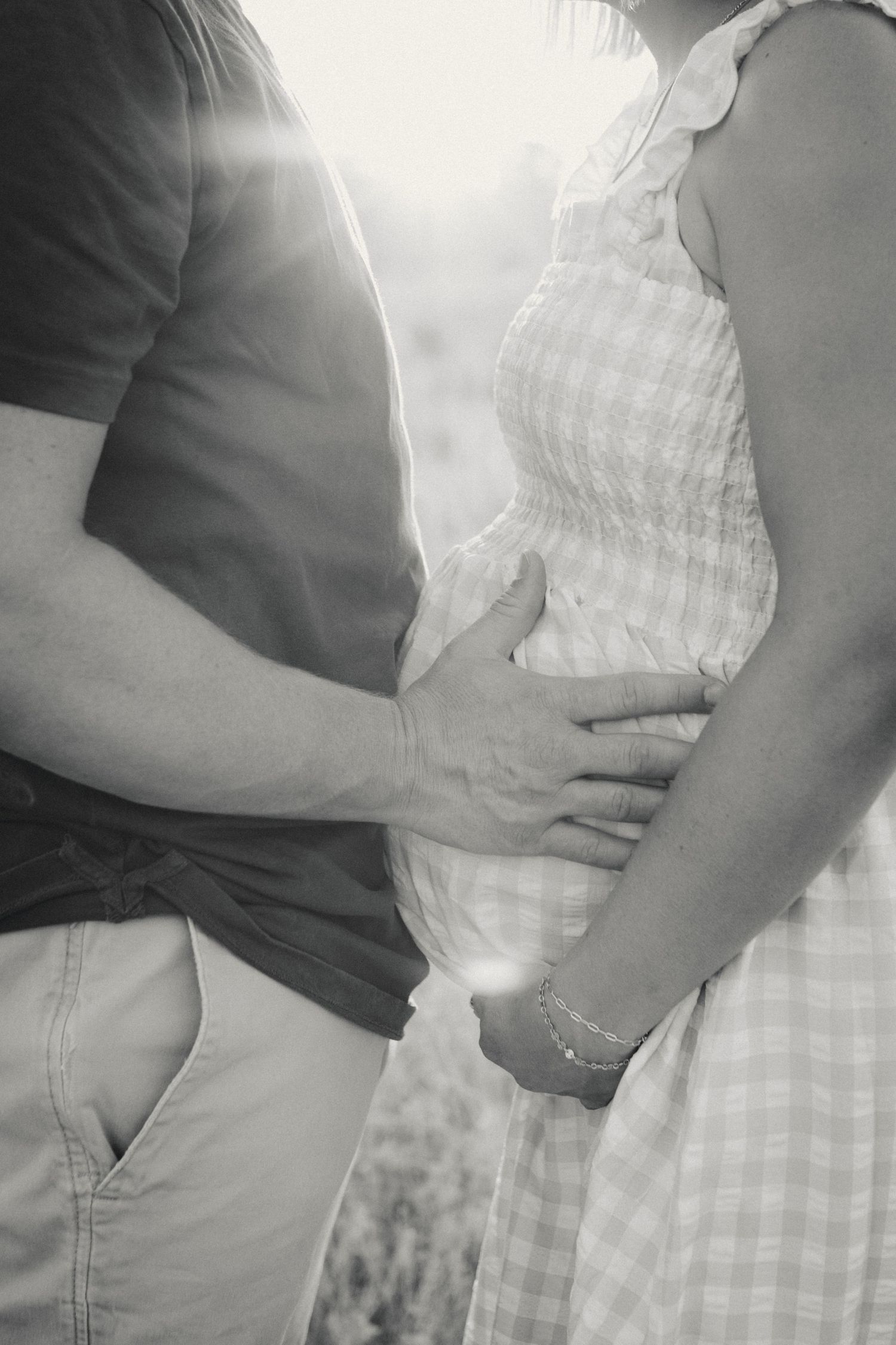 Close-up black and white maternity photo series showing hands resting on a pregnant belly.