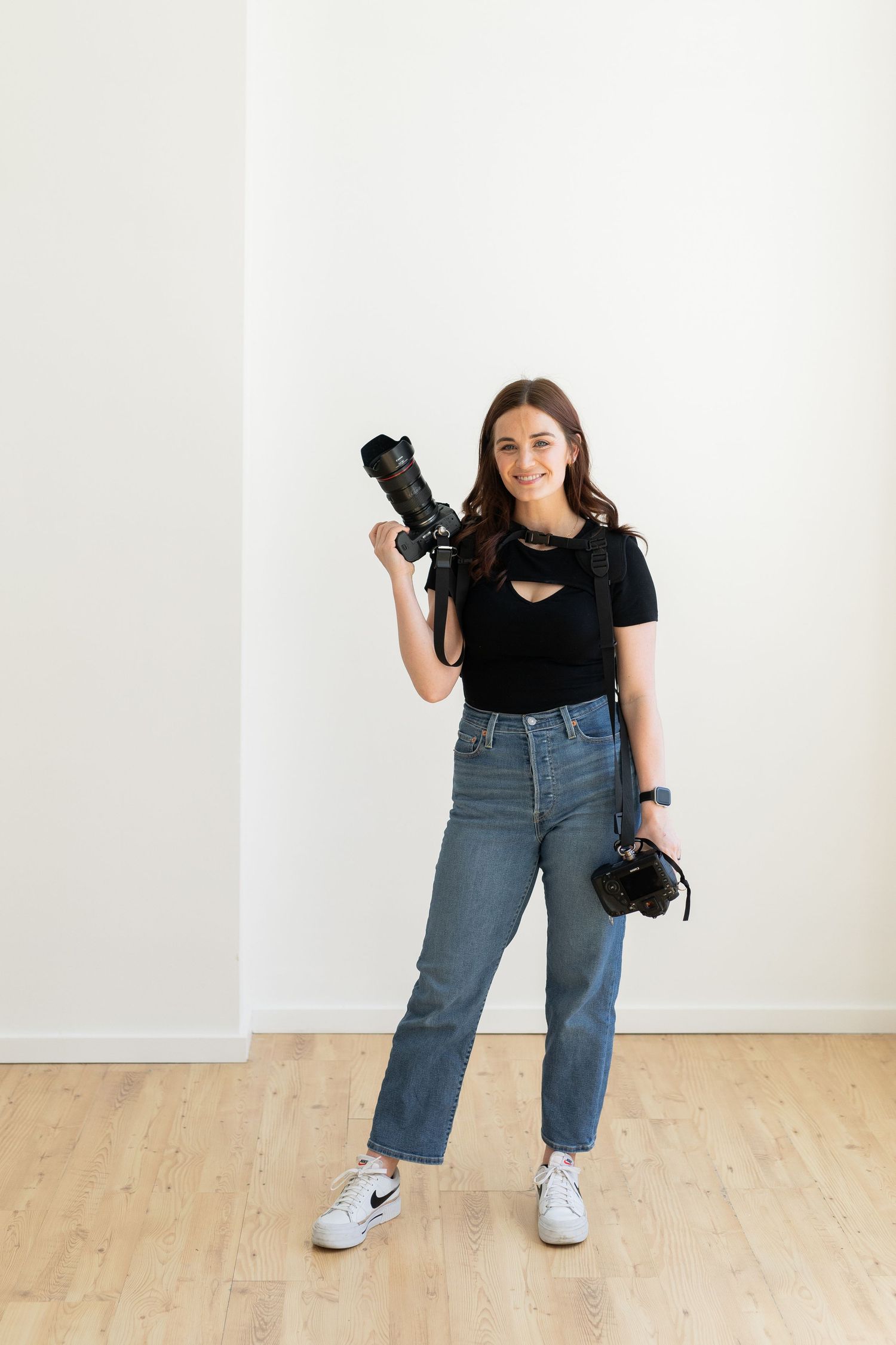 Dynamic studio shots showcasing photographer with cameras in casual denim and black outfit.