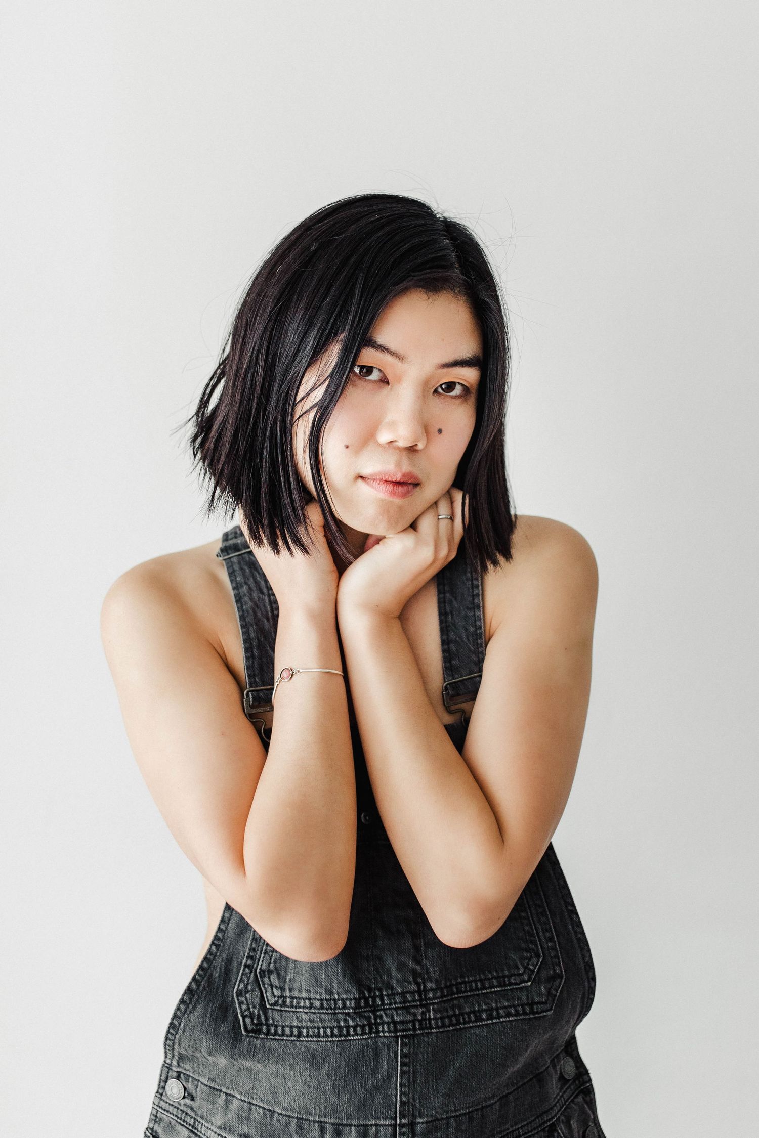 Studio portraits in black denim against white background showing various poses.