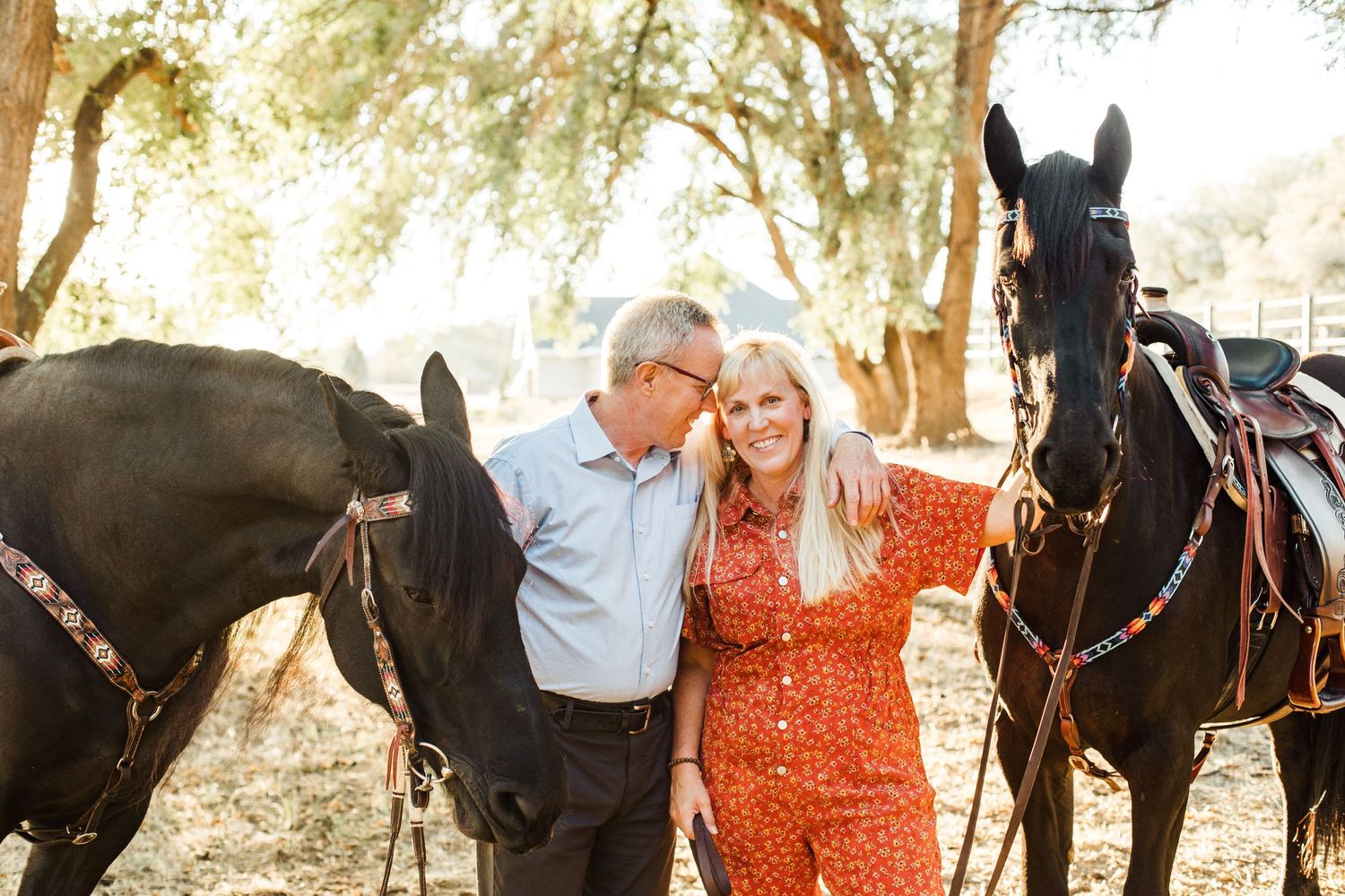 Engagement photos with a couple and their horse in a sun-dappled wooded setting.