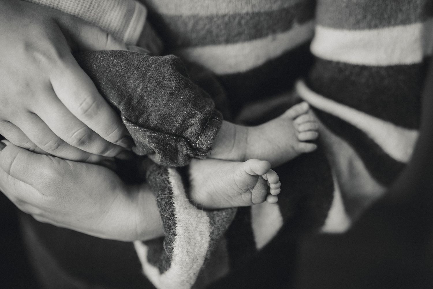 Black and white series of intimate window-lit moments showing gentle interaction with a baby.