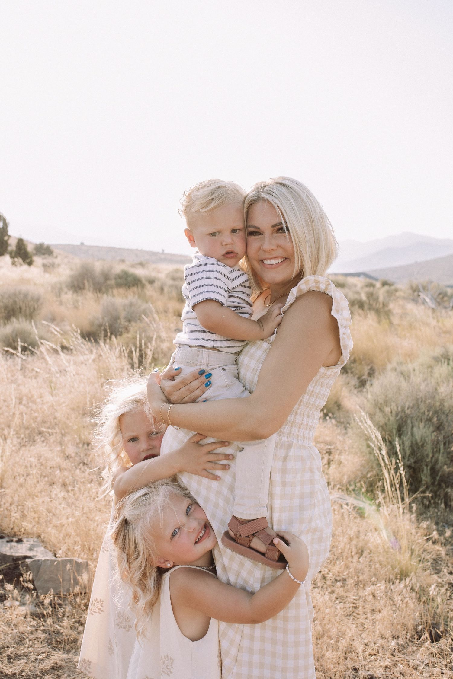 Sun-drenched family portrait session in a desert landscape with matching gingham outfits.