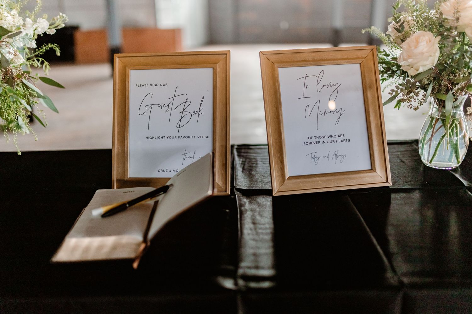 Elegant wedding guest book display with framed signs and floral arrangements.
