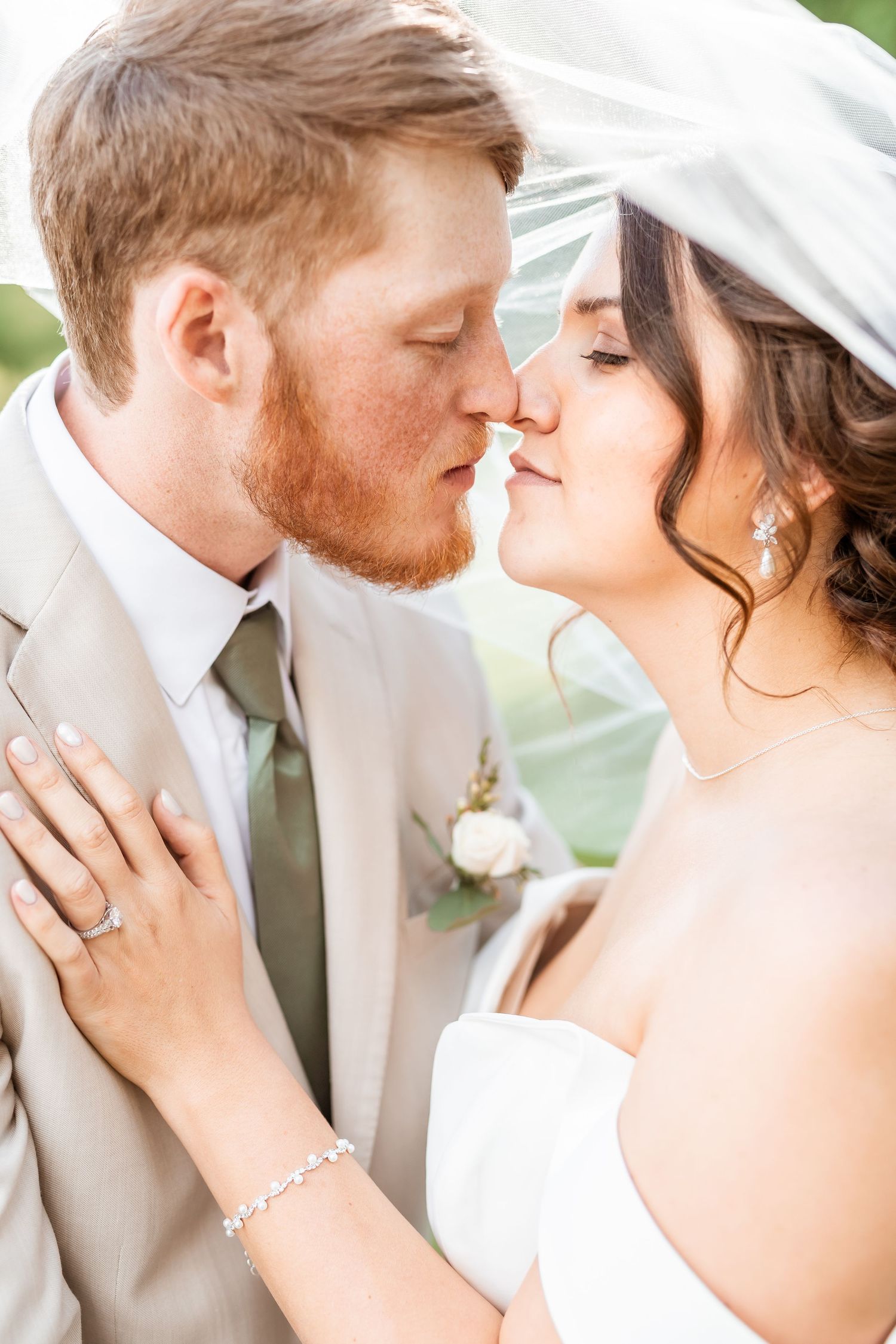 A romantic wedding couple shares an intimate moment under a white veil in a series of close-up shots.