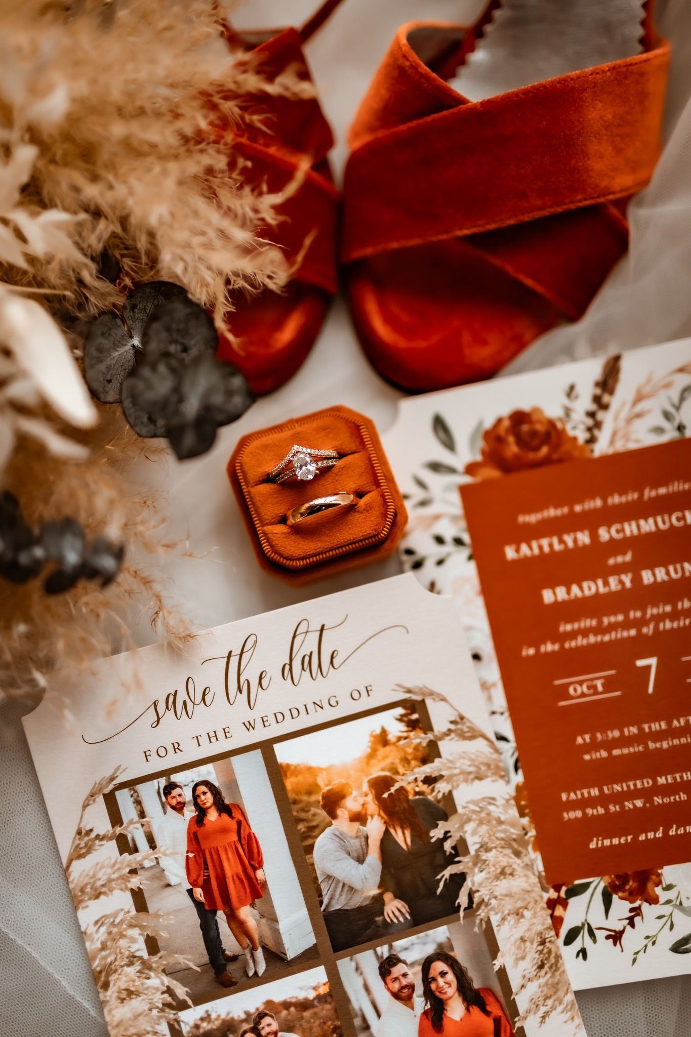 Wedding details flat lay with orange ring box, save the date card, and rustic decorations.
