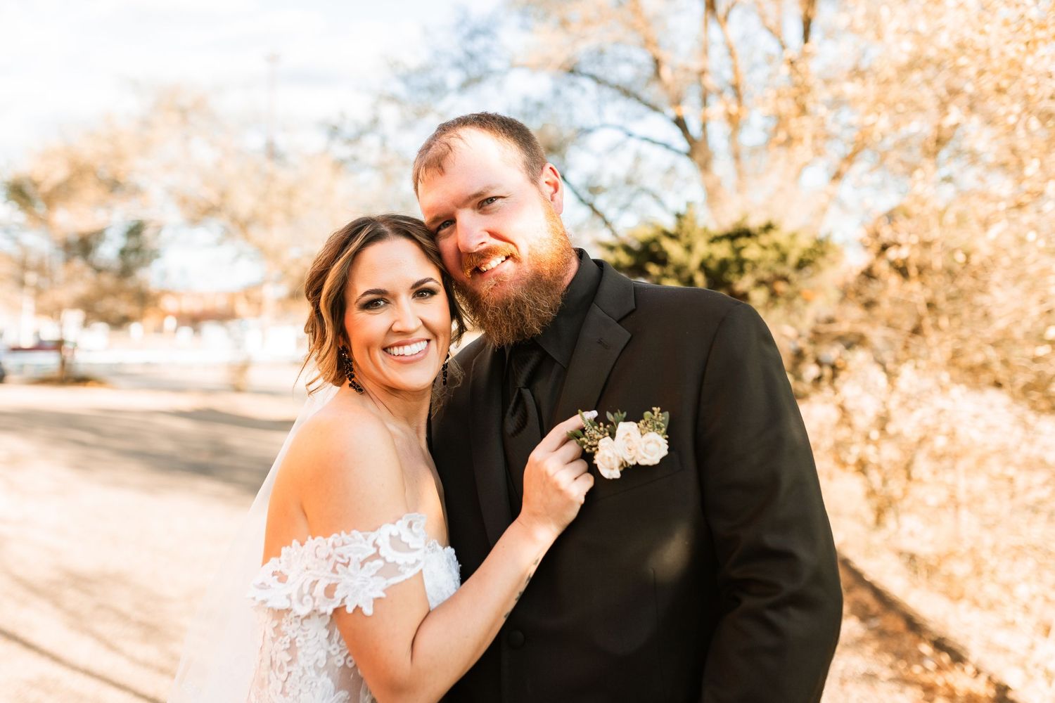 Romantic outdoor portrait of a couple on their wedding day in warm sunlight.