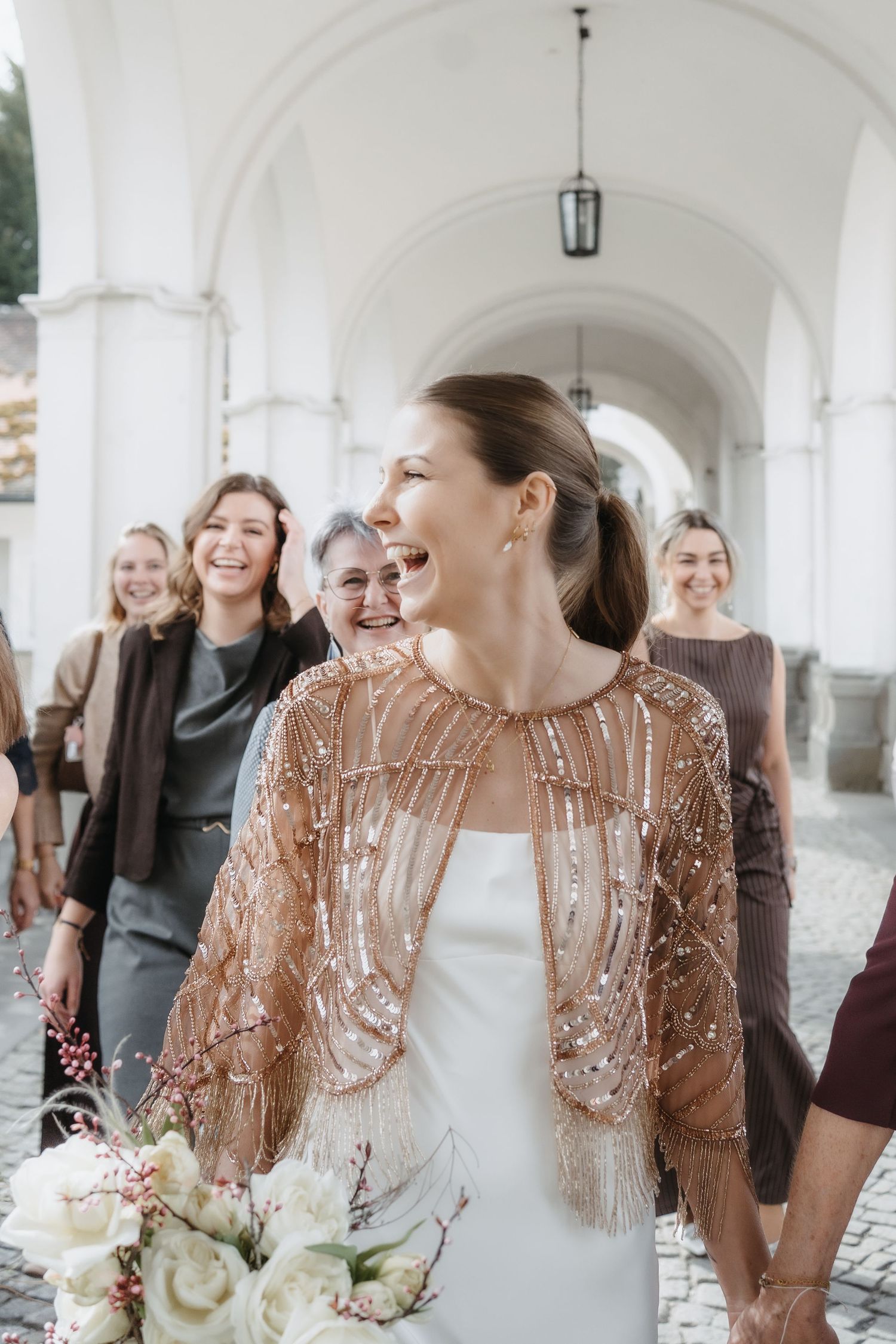 Von Herzen lachende Braut wie sie mit ihren Freundinnen Fotografiert wird