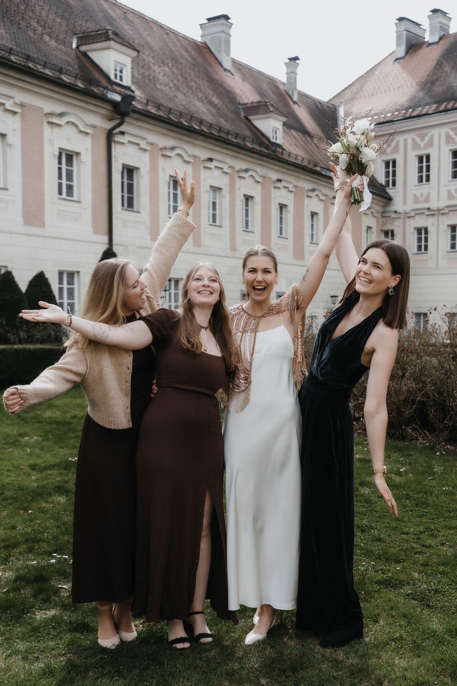 Schönes Gruppenbild im Schloss mit gedeckten Farben im Hontergrund geht die Sonne hinter dem Schloss nieder
