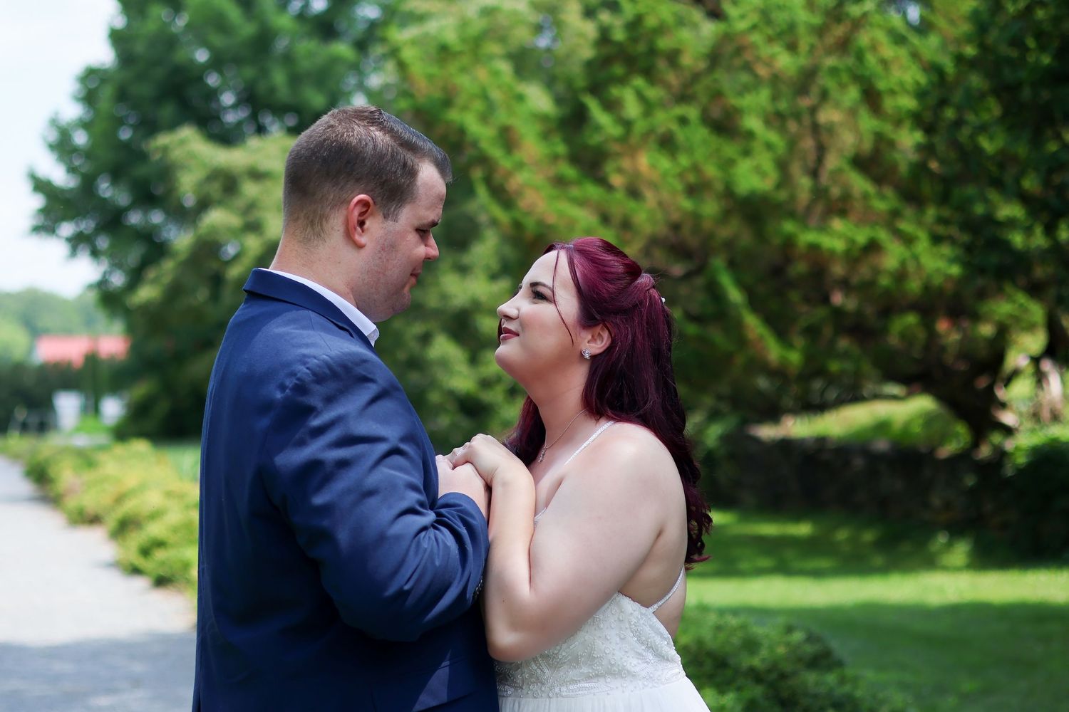 A happy couple shares a joyful moment together in a garden setting on their wedding day.