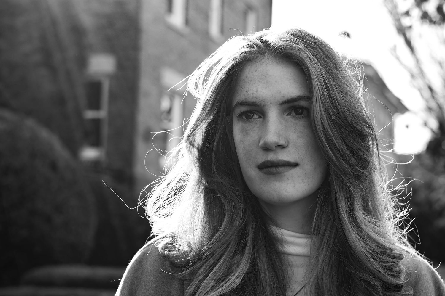 A series of black and white portrait photographs showing the same person with flowing hair in different poses.