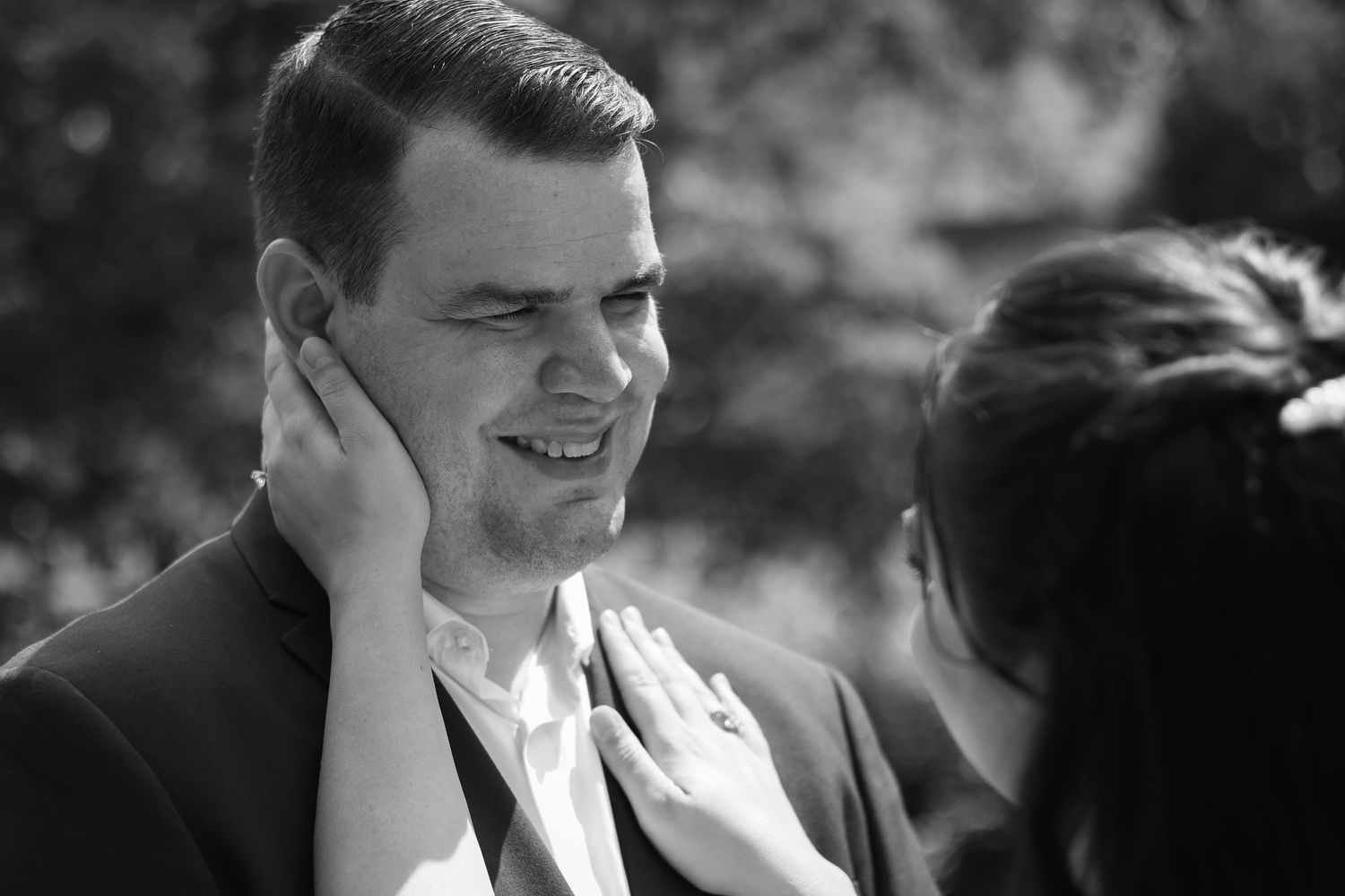 A black and white photo collage shows a person smiling and laughing in different candid expressions.