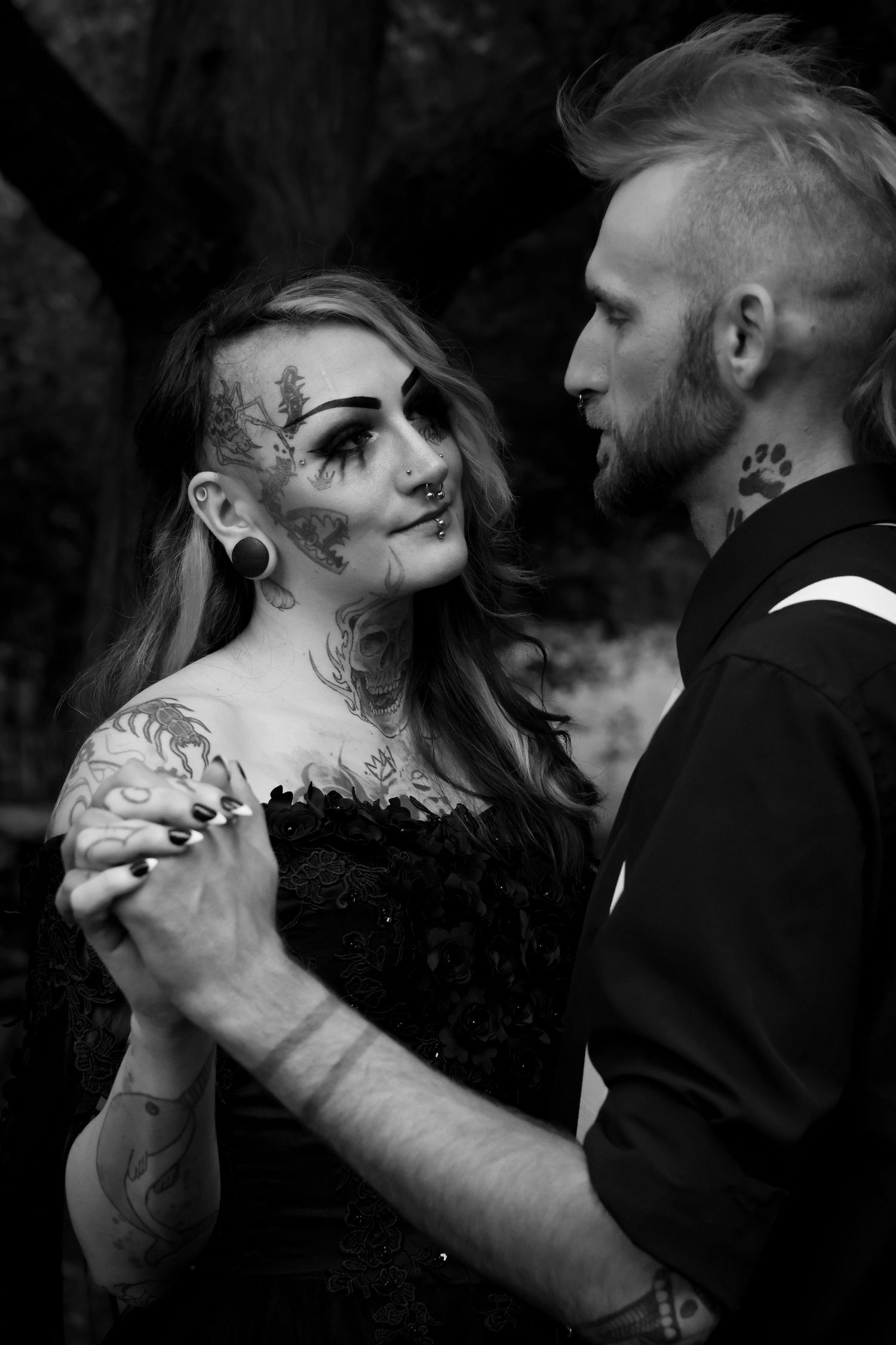 A black and white photo series shows an intimate dance between two people with dramatic face paint and formal attire.