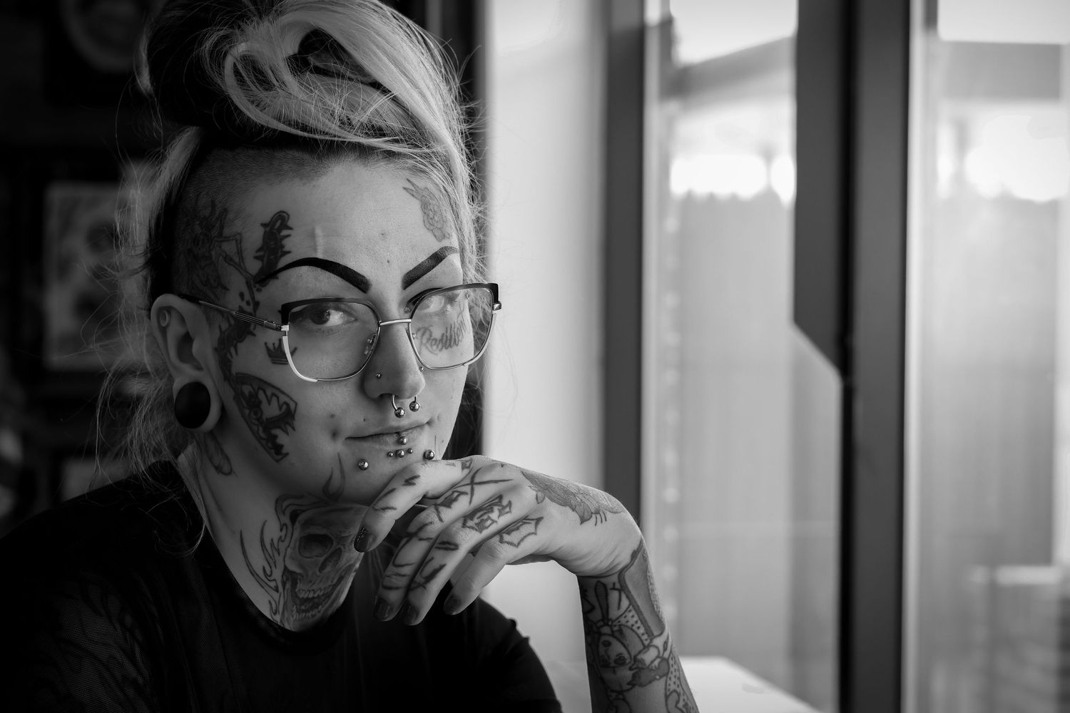 Black and white portrait photos of a person in glasses arranged in a grid format.