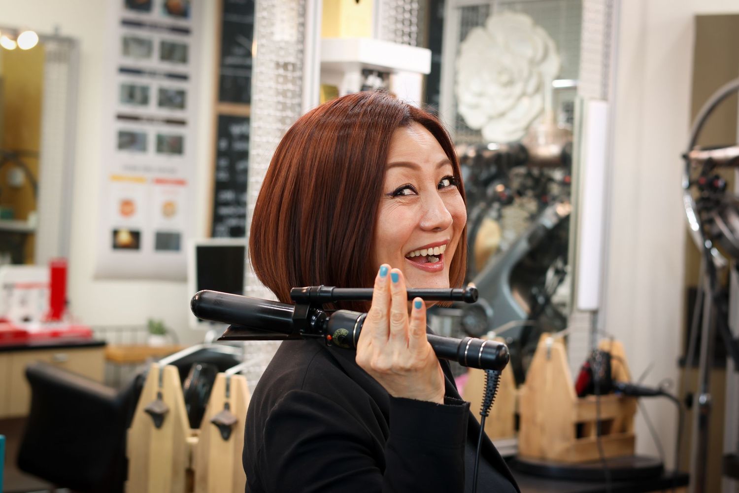 A hairstylist works on styling a client's hair in a modern salon interior.