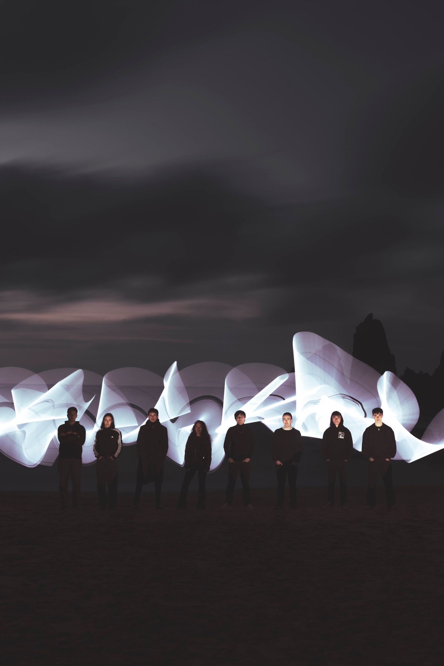 Illuminated white ice sculptures glowing against dark night sky.