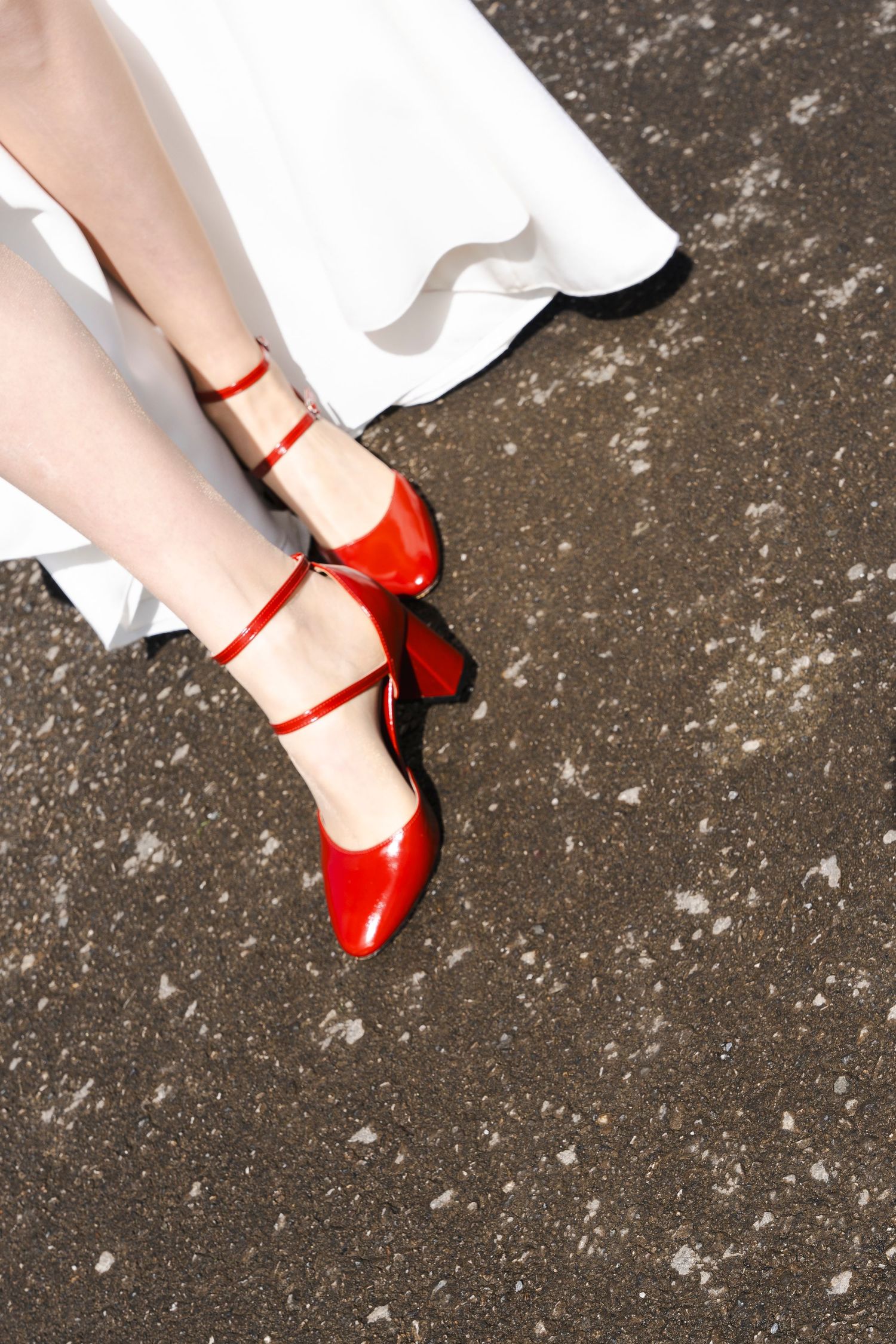 Close-up of bride's feet wearing vibrant red vintage-style Mary Jane shoes.