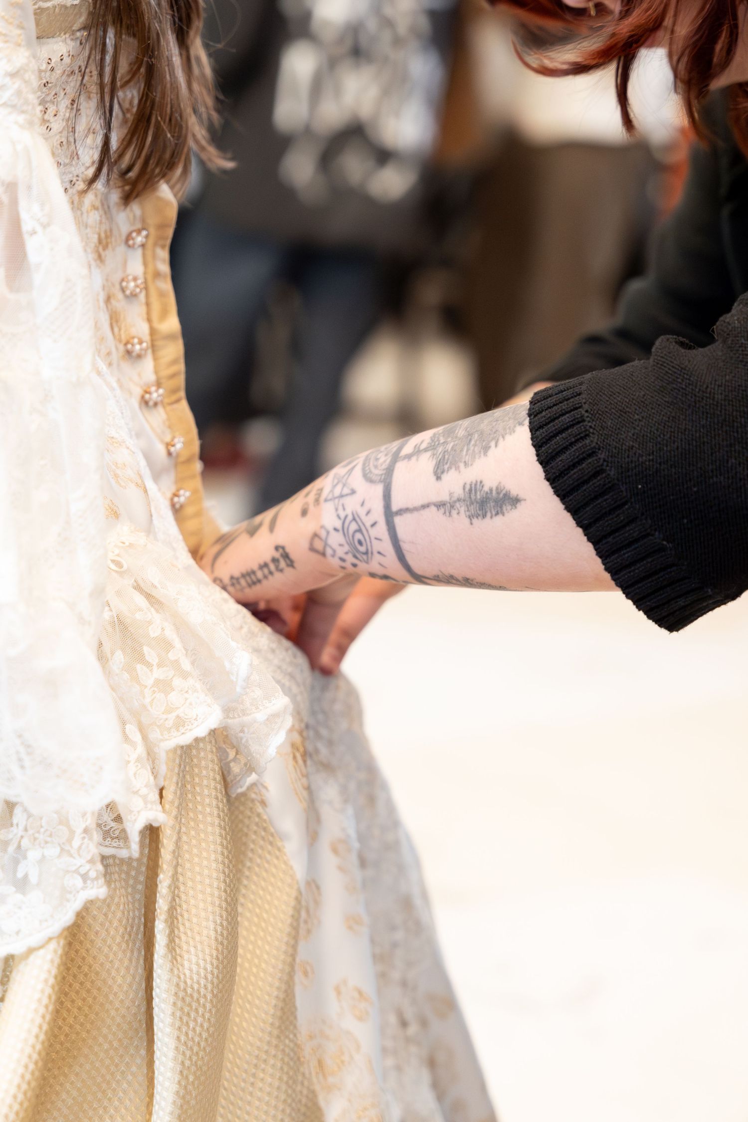Close-up of detailed lace fabric on vintage-style cream colored dress.