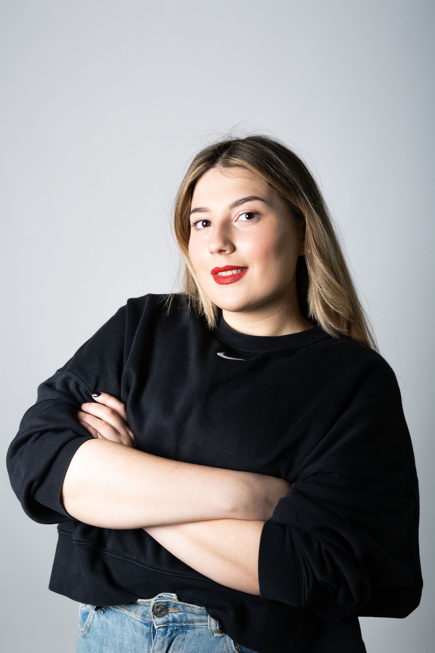 Studio portraits featuring casual black sweater and expressive poses against gray background.