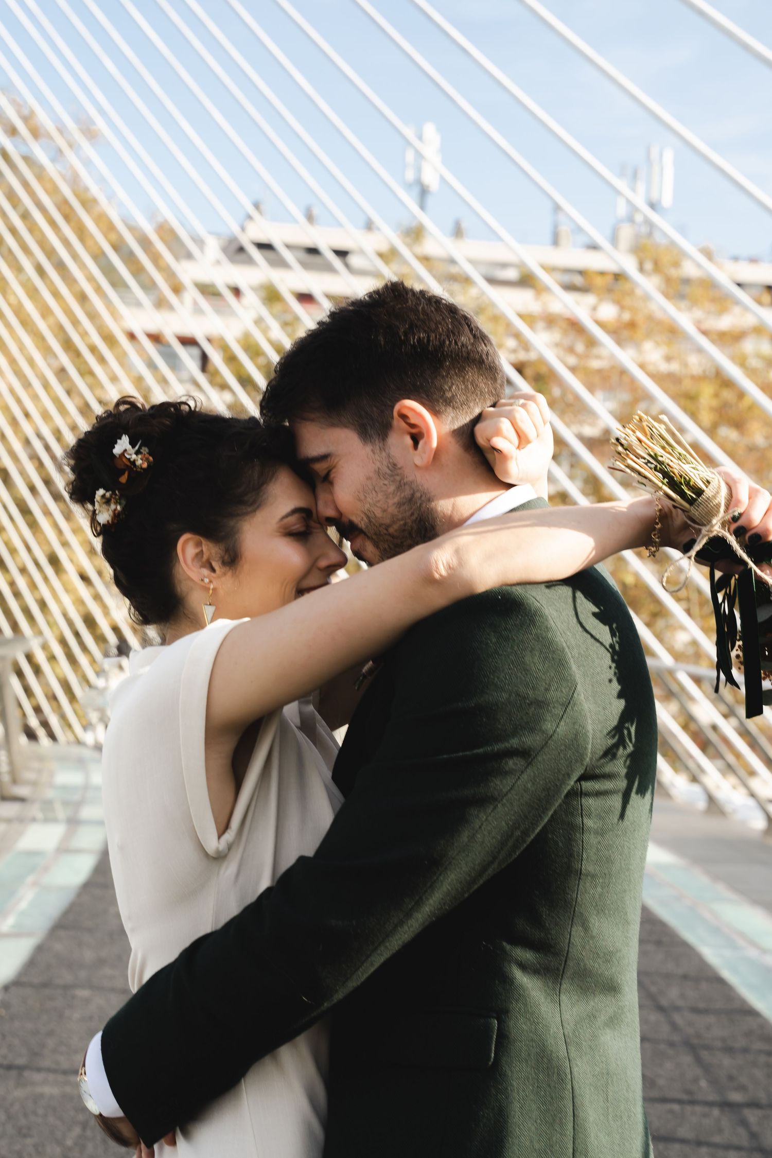 Intimate moment between couple embracing against modern architectural background.