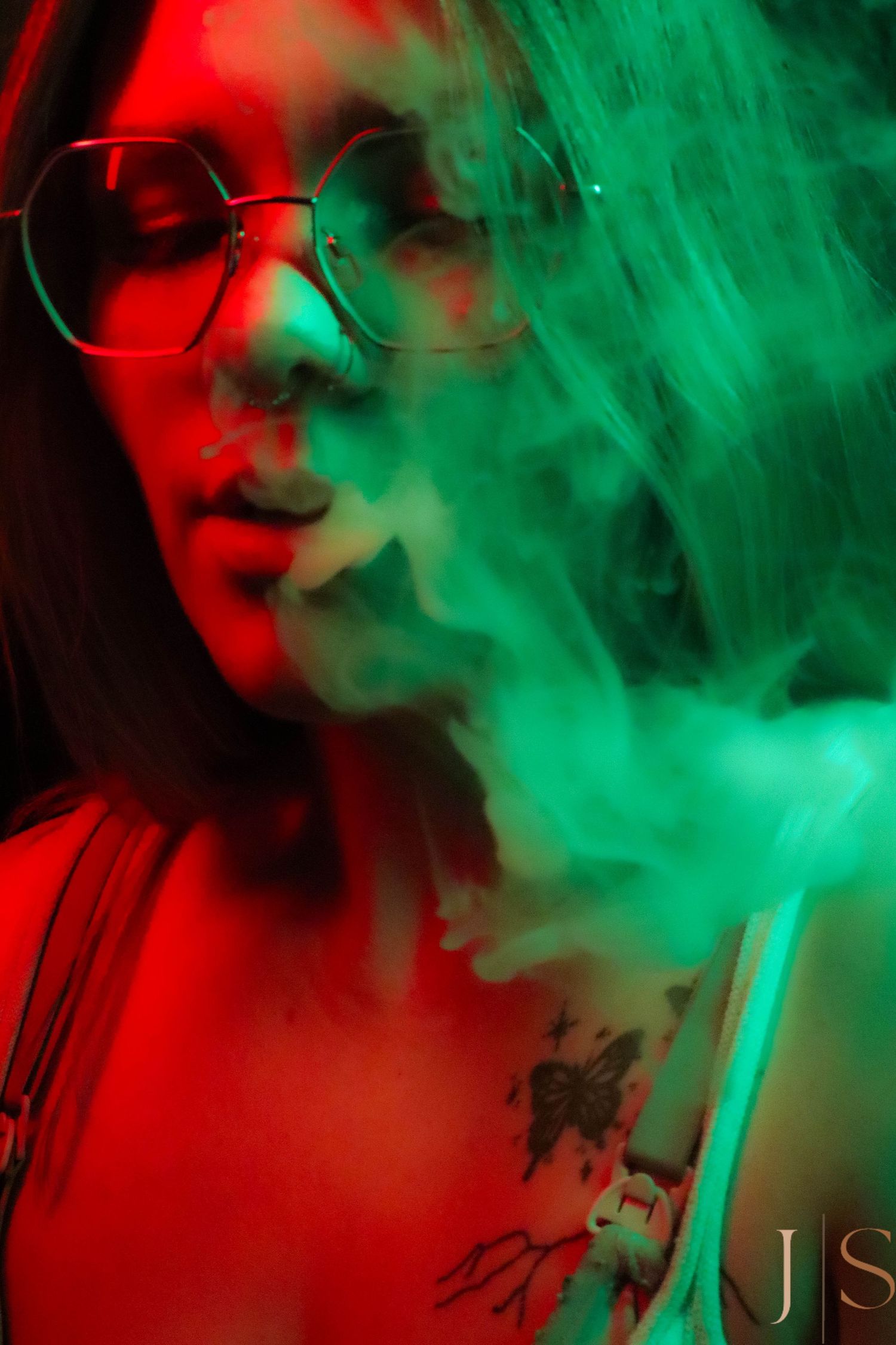 Artistic abstract photo with swirling red and green smoke effects creating a dramatic atmosphere in darkness.