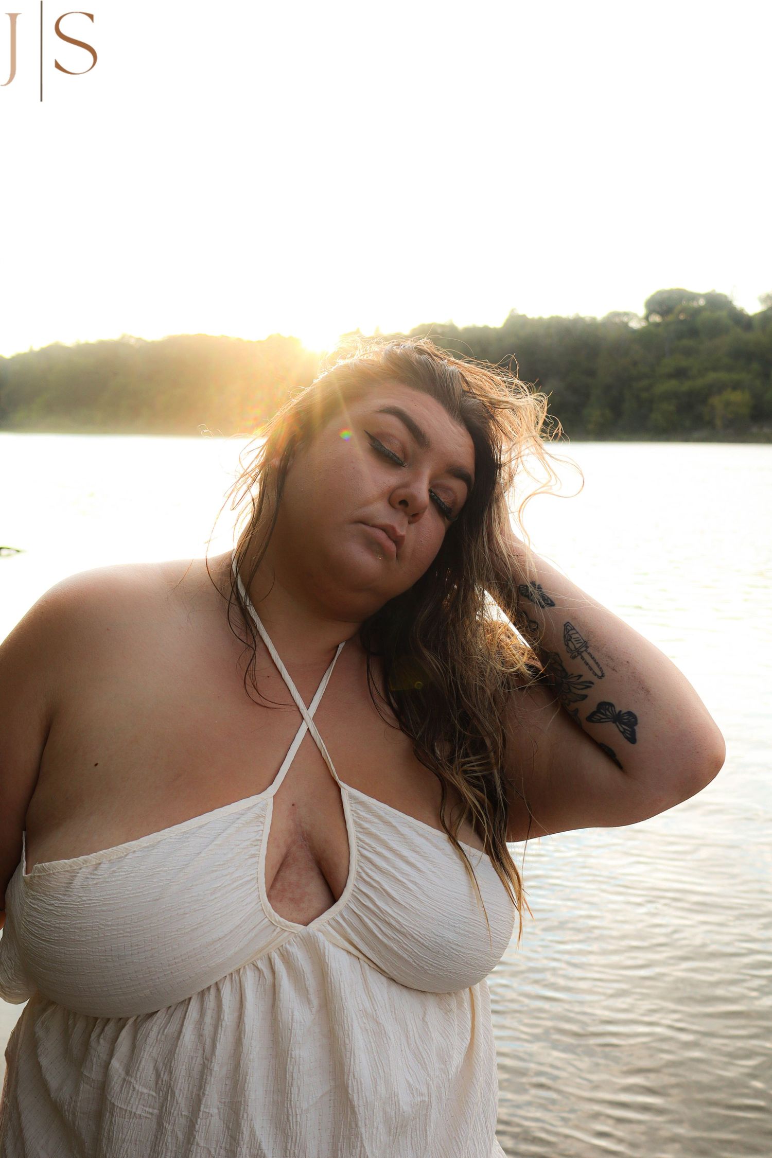A series of artistic portraits by a lake at sunset with soft lighting and white attire.