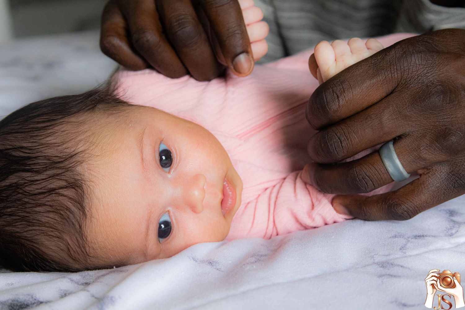 Diverse hands tenderly caring for a baby resting on white bedding in a heartwarming sequence of images.