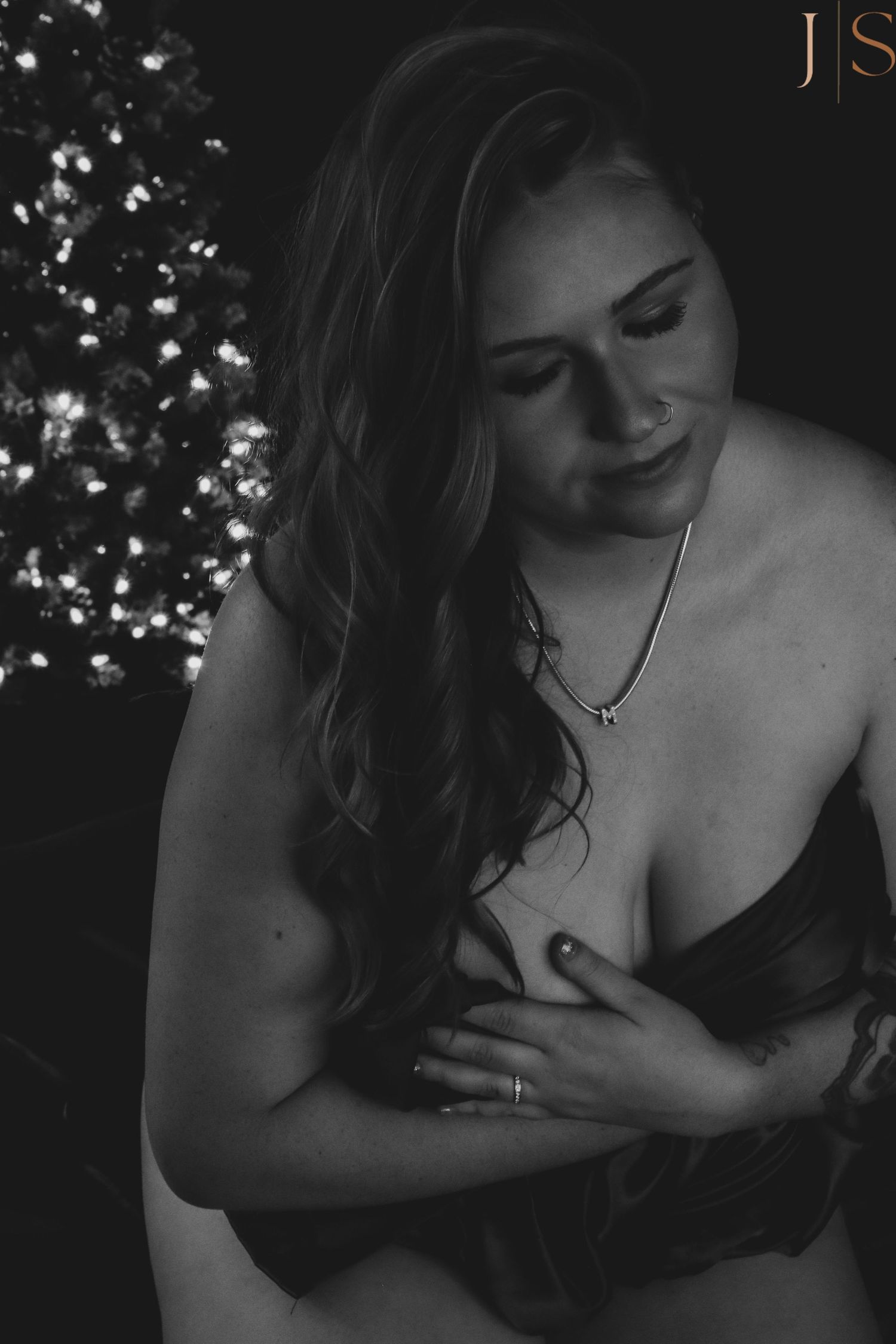Black and white artistic boudoir photo series showing intimate moments in dramatic lighting against dark background.