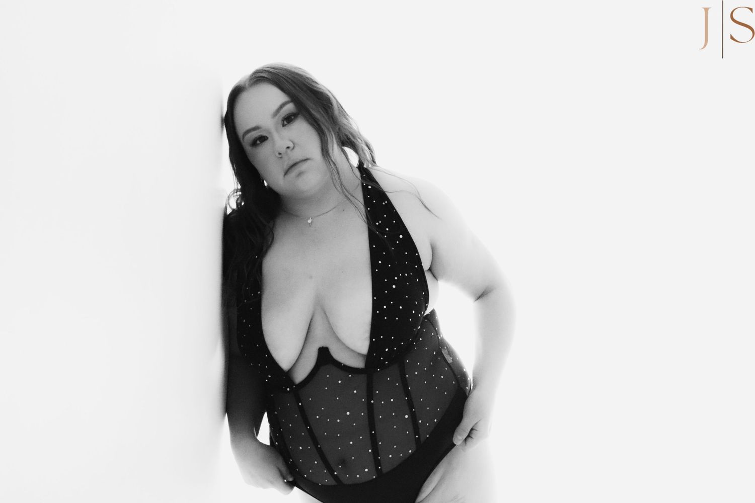A person in a black outfit poses against a white background in a series of artistic portraits.
