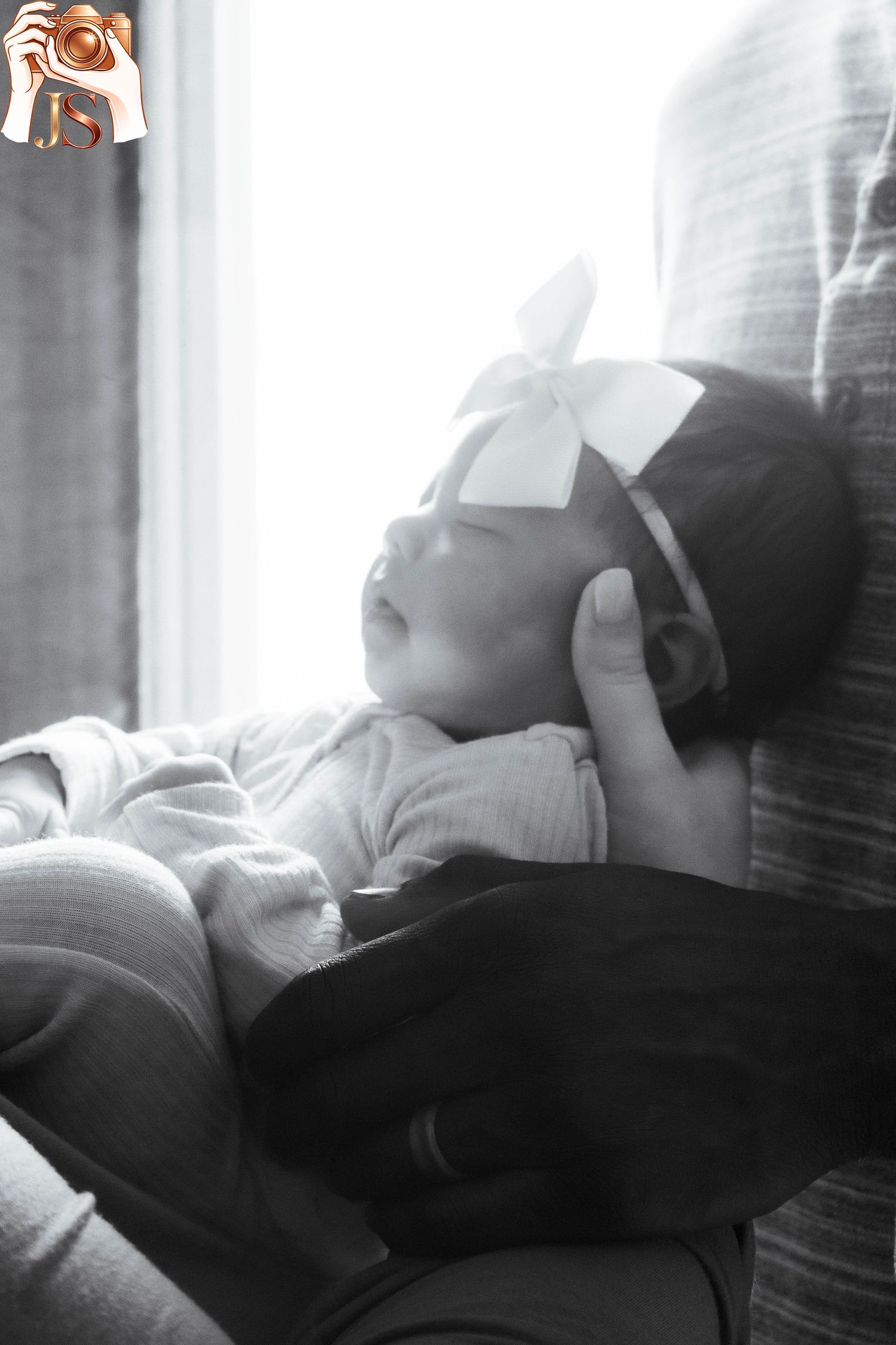 Intimate black and white photograph showing silhouettes of two people resting together in natural light.