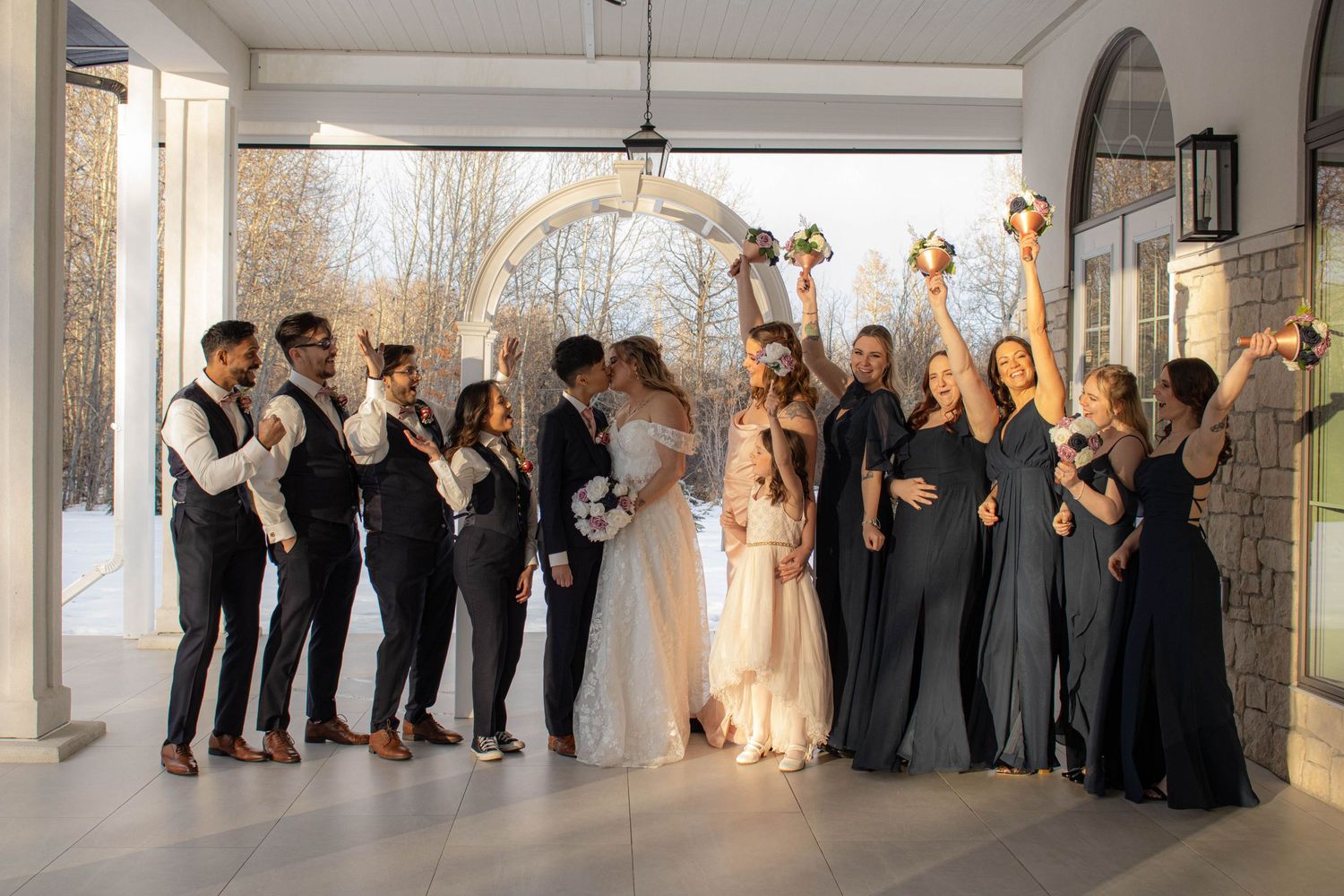 Wedding party celebration in an elegant white venue with bridesmaids and groomsmen.