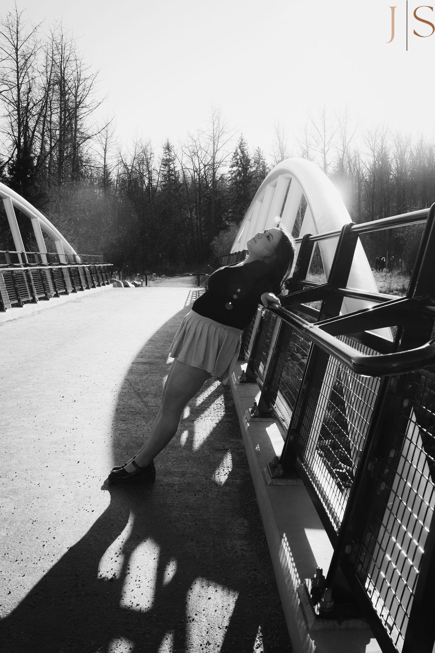 Winter bridge scene with dramatic shadows and silhouettes against snowy backdrop.