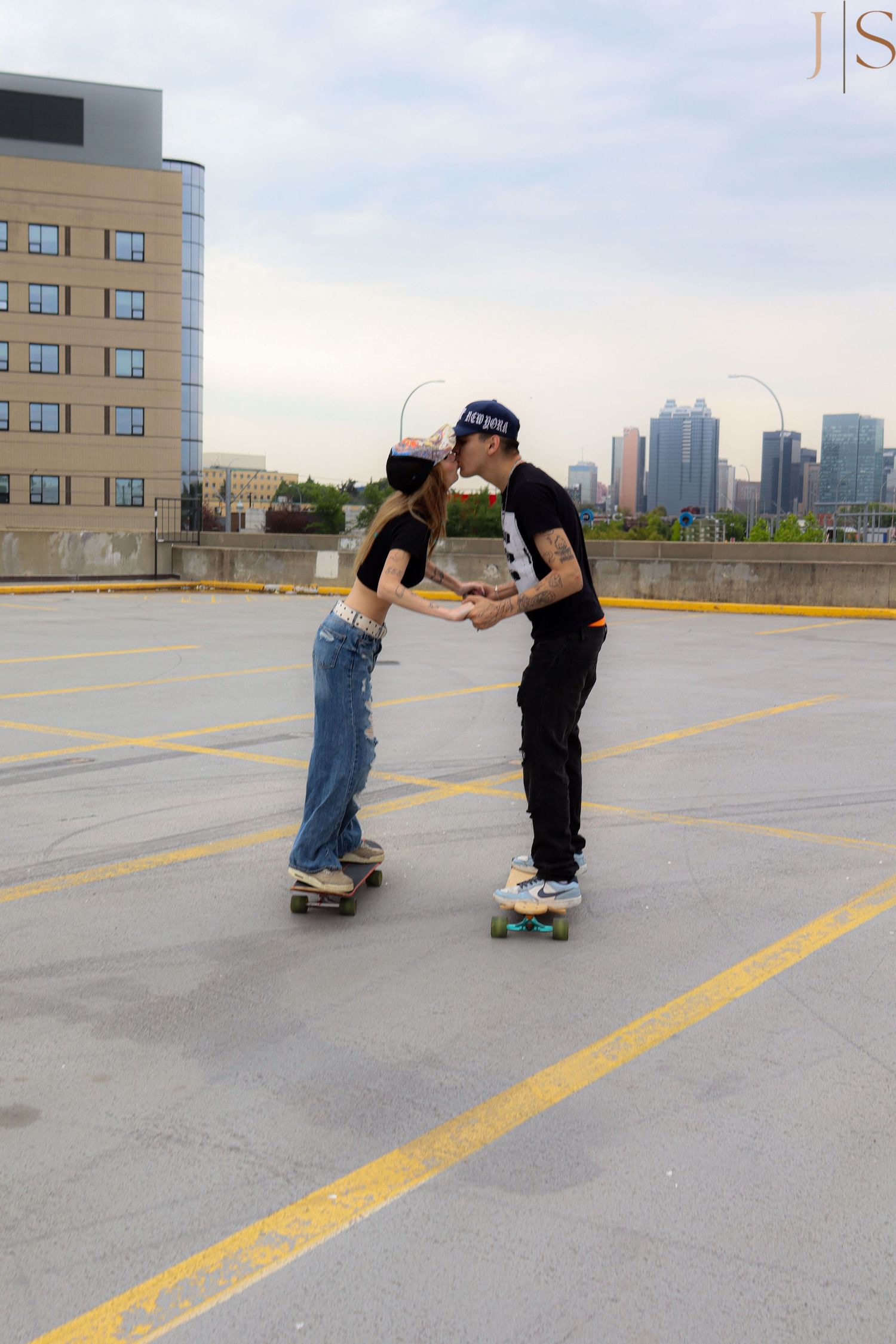Sequence of skateboarders practicing tricks and supporting each other on a rooftop parking lot with city skyline.