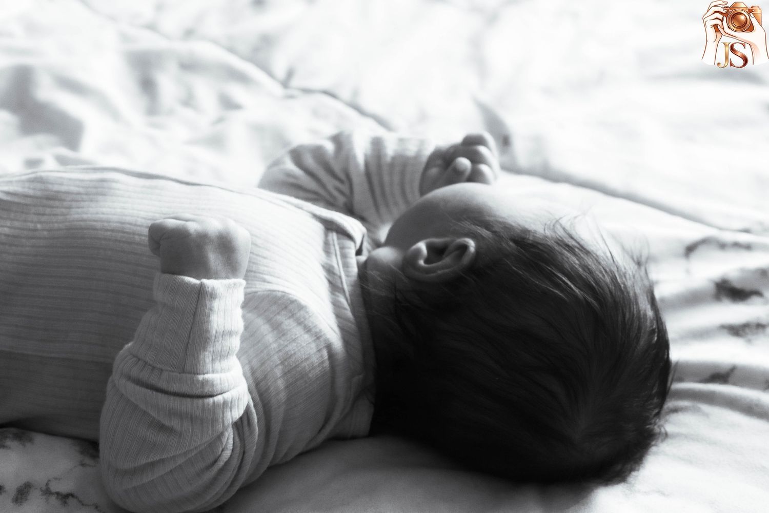Black and white photo series showing sleeping infant in white bedding.