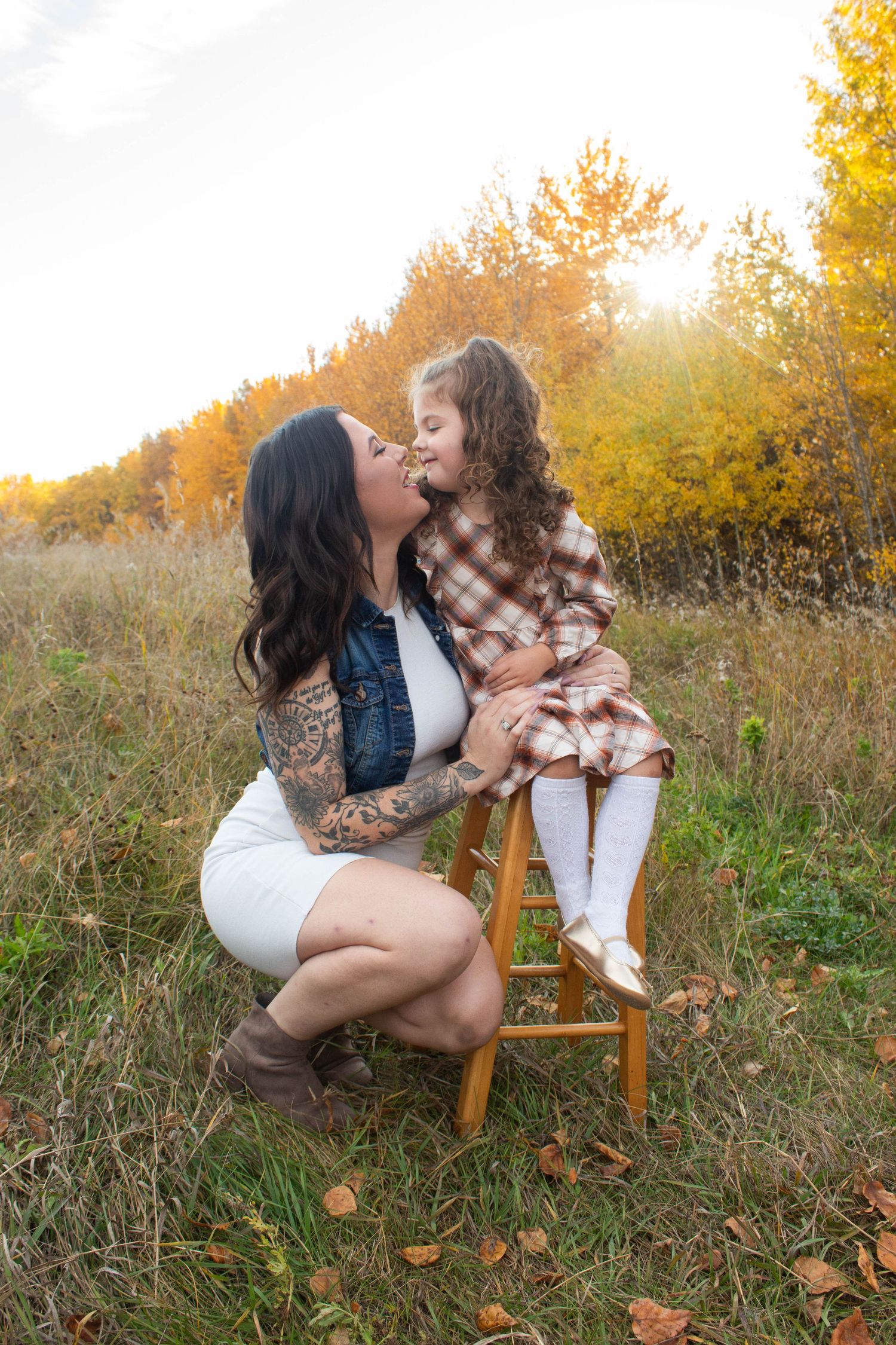 Heartwarming fall portrait with matching plaid outfits in golden autumn field.
