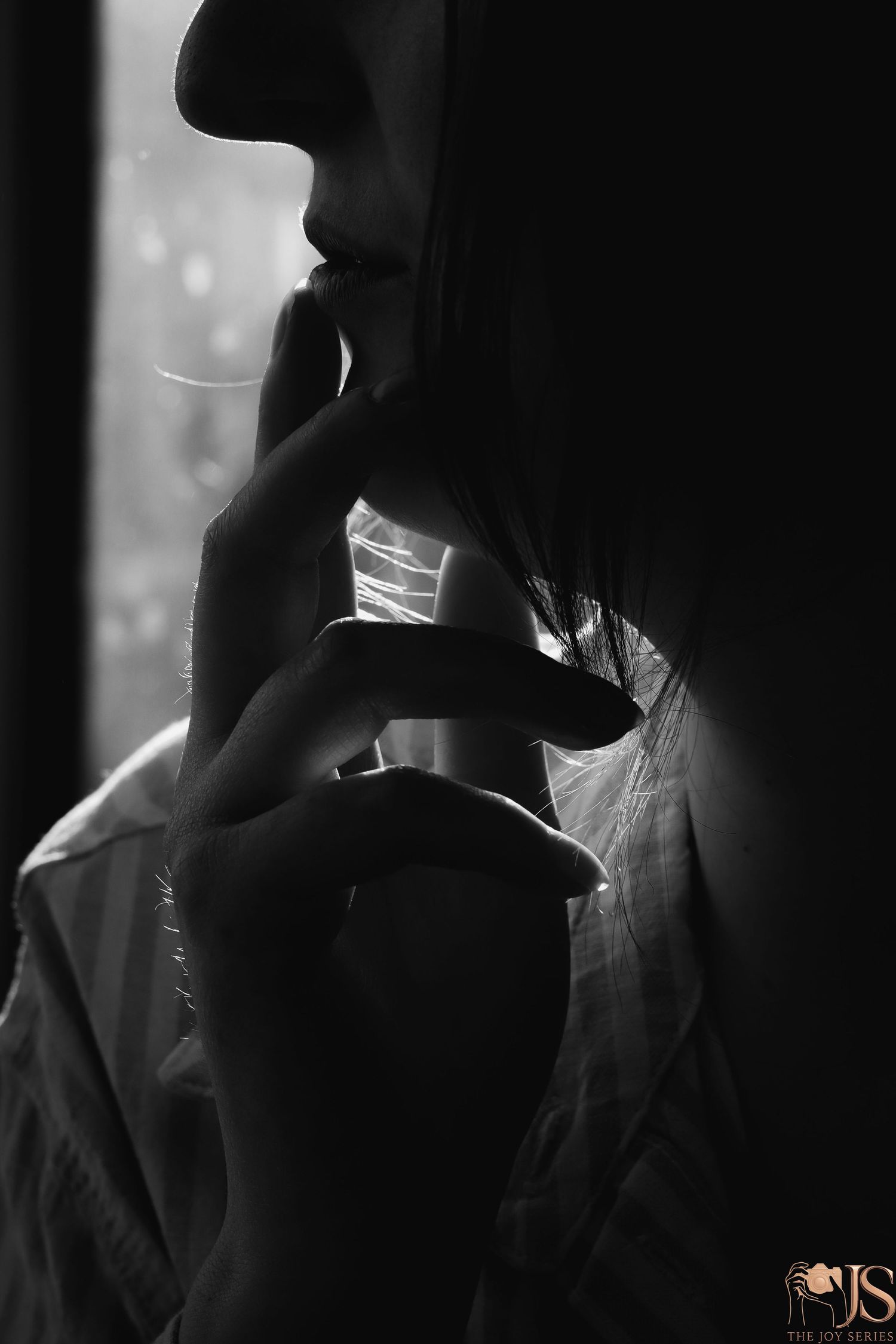A silhouetted figure in black and white holds a glass in a moody, atmospheric setting.