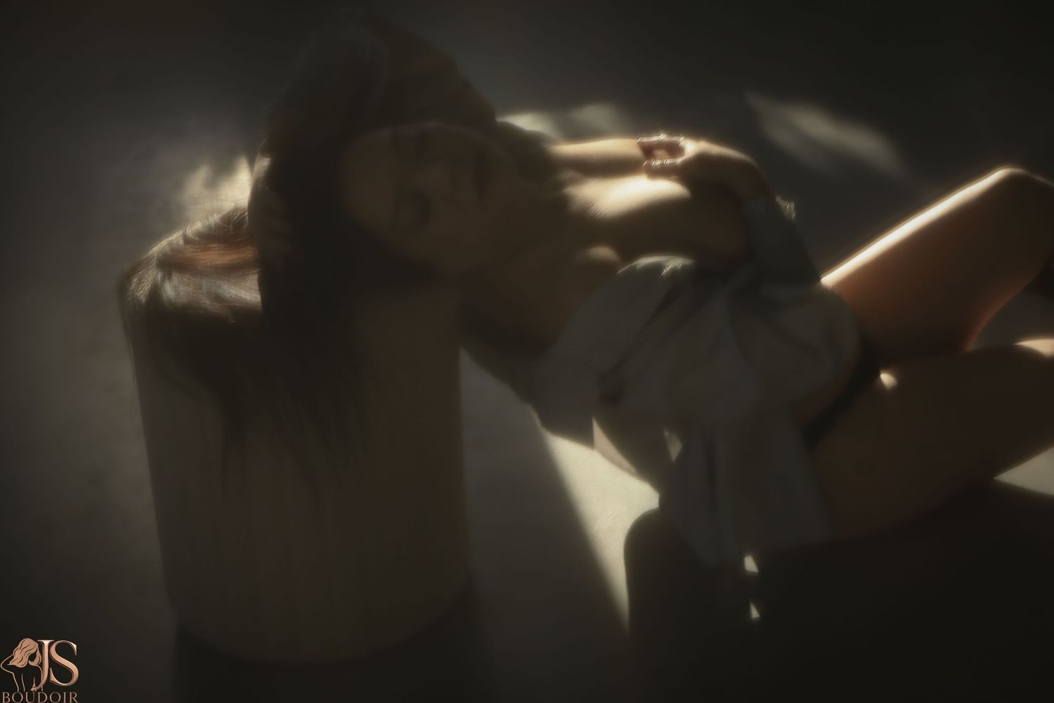 Moody shadows and light create dramatic contrast in an intimate indoor portrait.