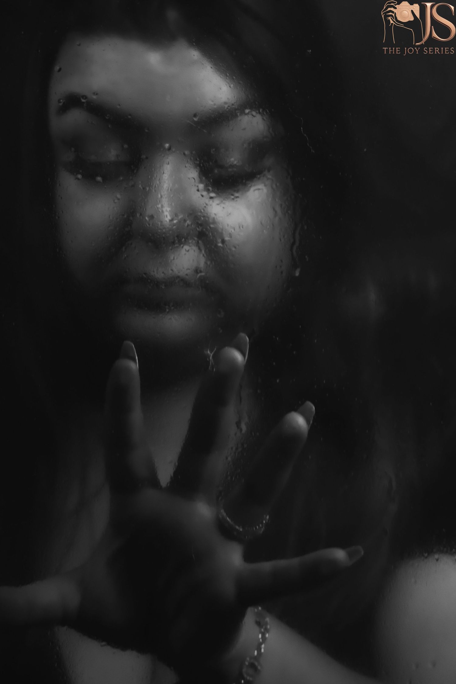 Dramatic black and white close-up portrait with moody lighting and shadows creating an artistic atmospheric effect.