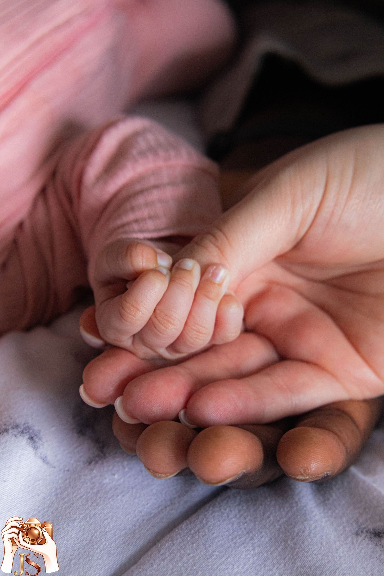 Close-up series of hands holding and gently caressing a baby's tiny fingers against a soft white background.