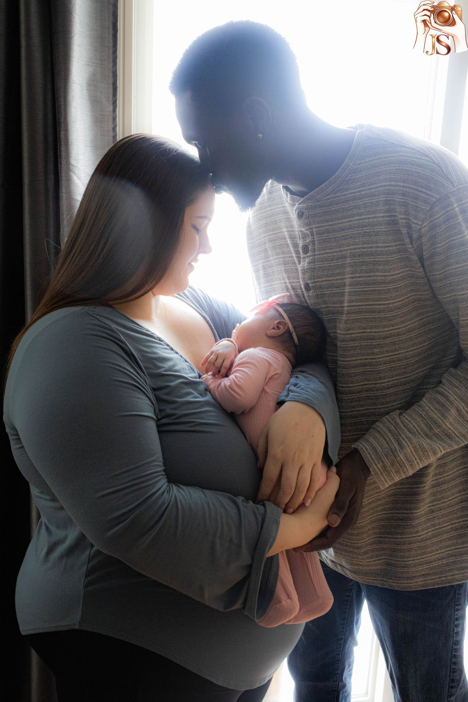 Backlit sequence showing intimate family moments as parents hold and interact with their newborn baby.