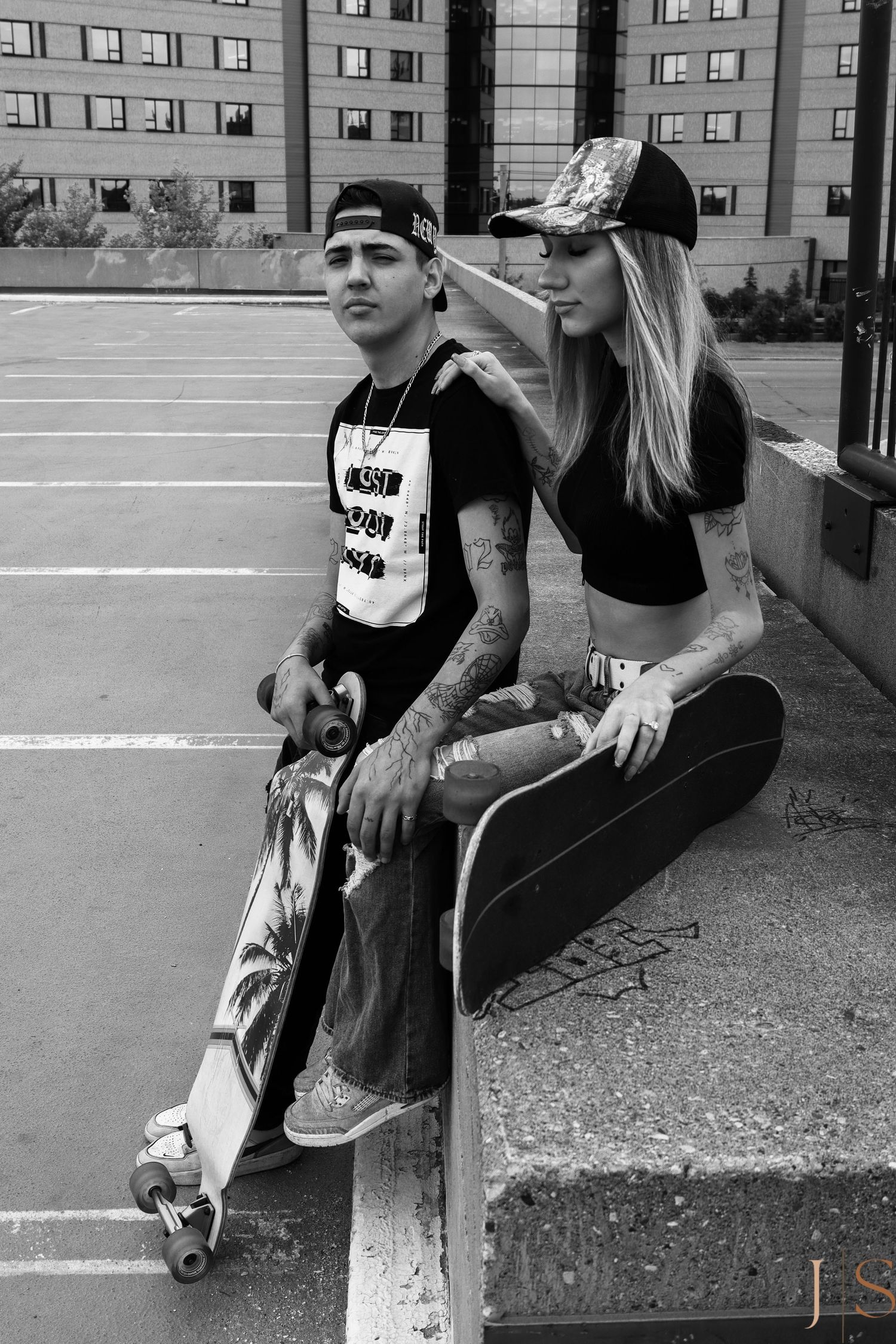 Black and white photo series of skateboarders sitting and posing with their boards in an urban setting.