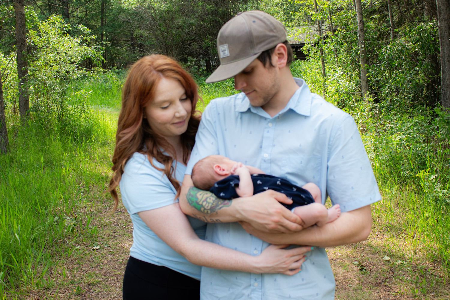 A family shares an intimate moment together on a forest path.