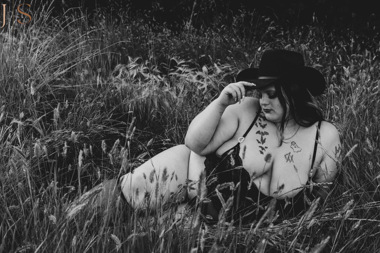 A romantic black and white photo sequence showing a couple lying in grass sharing tender moments together.