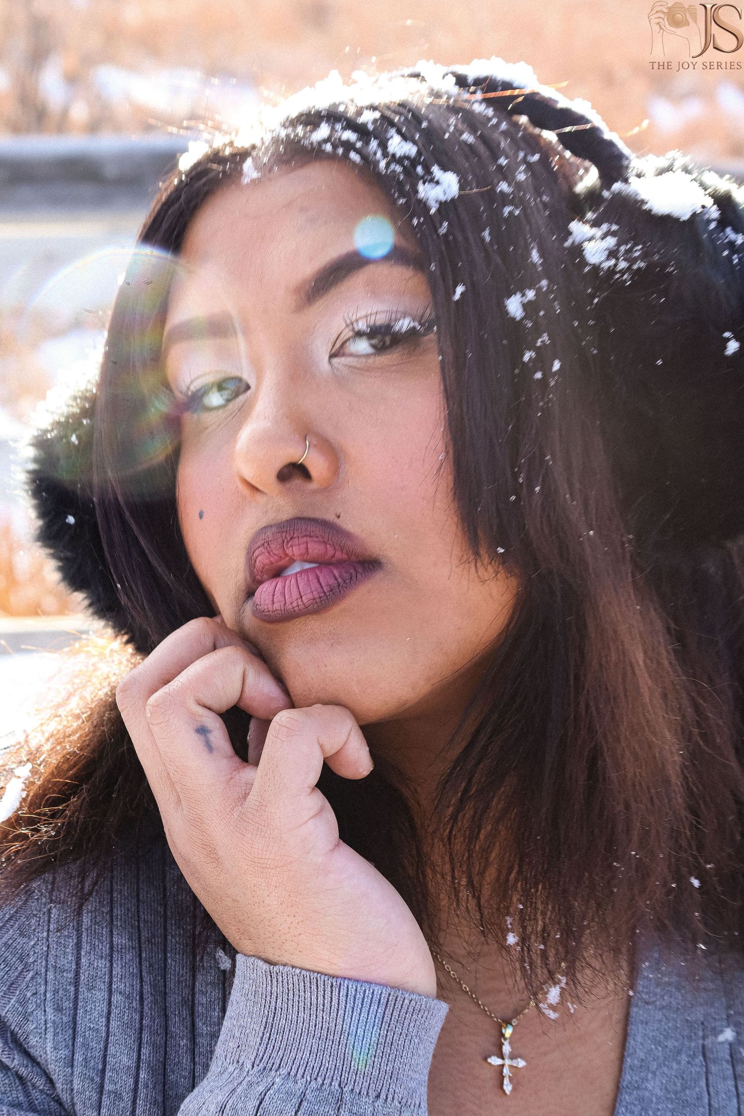 Artistic winter portrait series with snowflakes and soft lighting against a peachy background.