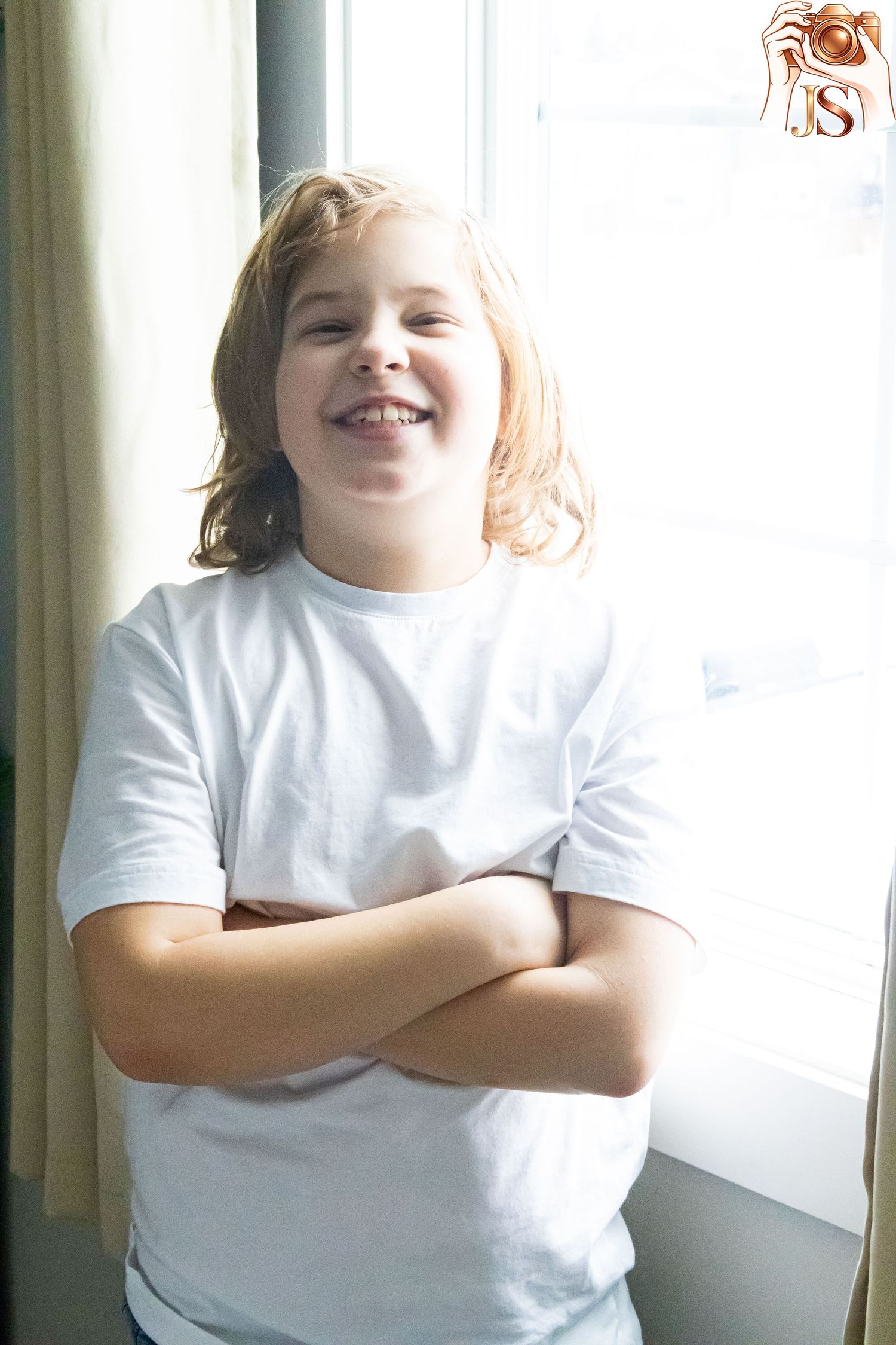 A child in a white t-shirt stands against a window, showing different playful poses in a sequence of photos.