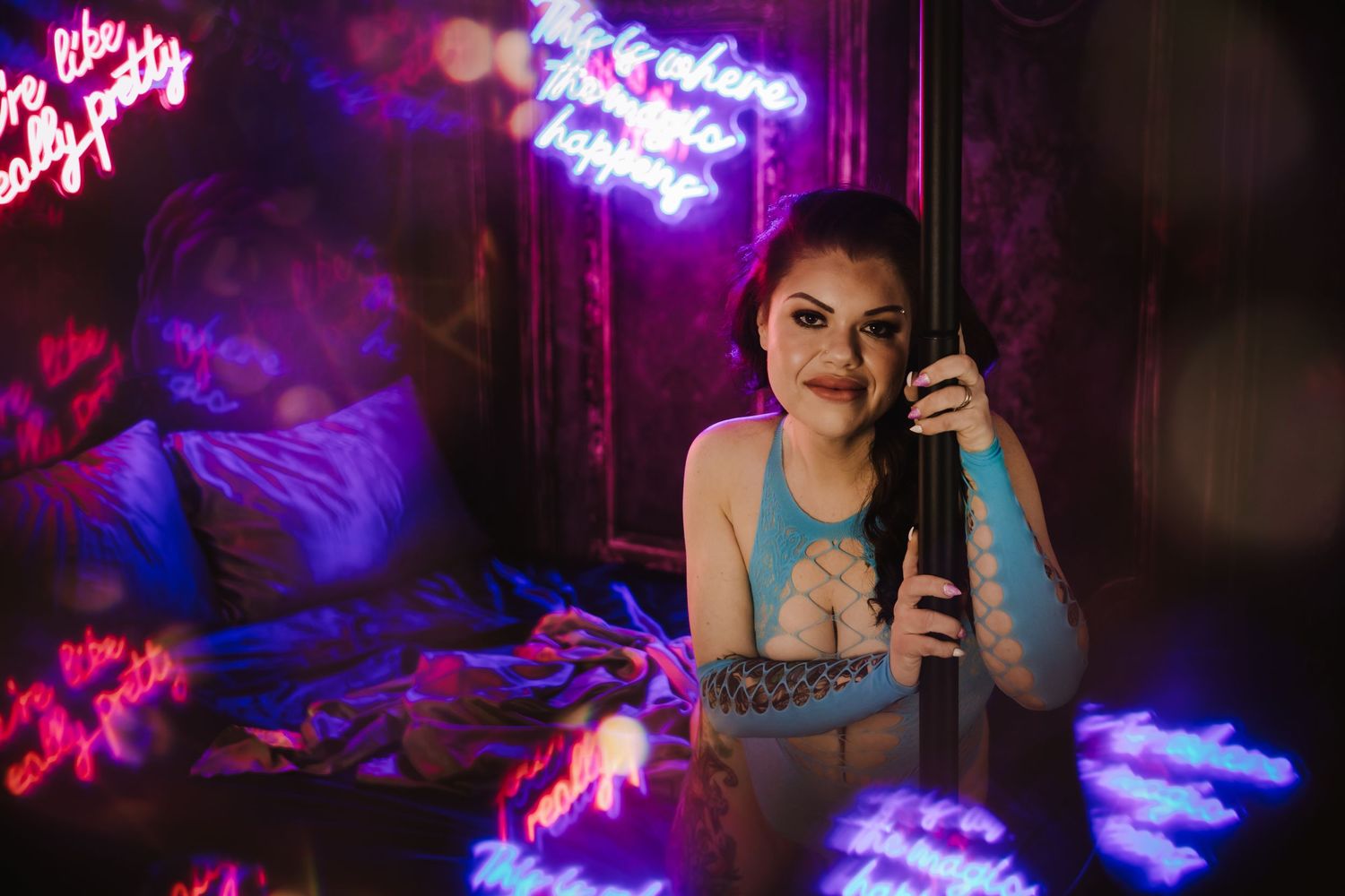 Neon lights cast vibrant purple and blue hues in a dimly lit bar or nightclub setting with a circular bokeh effect.