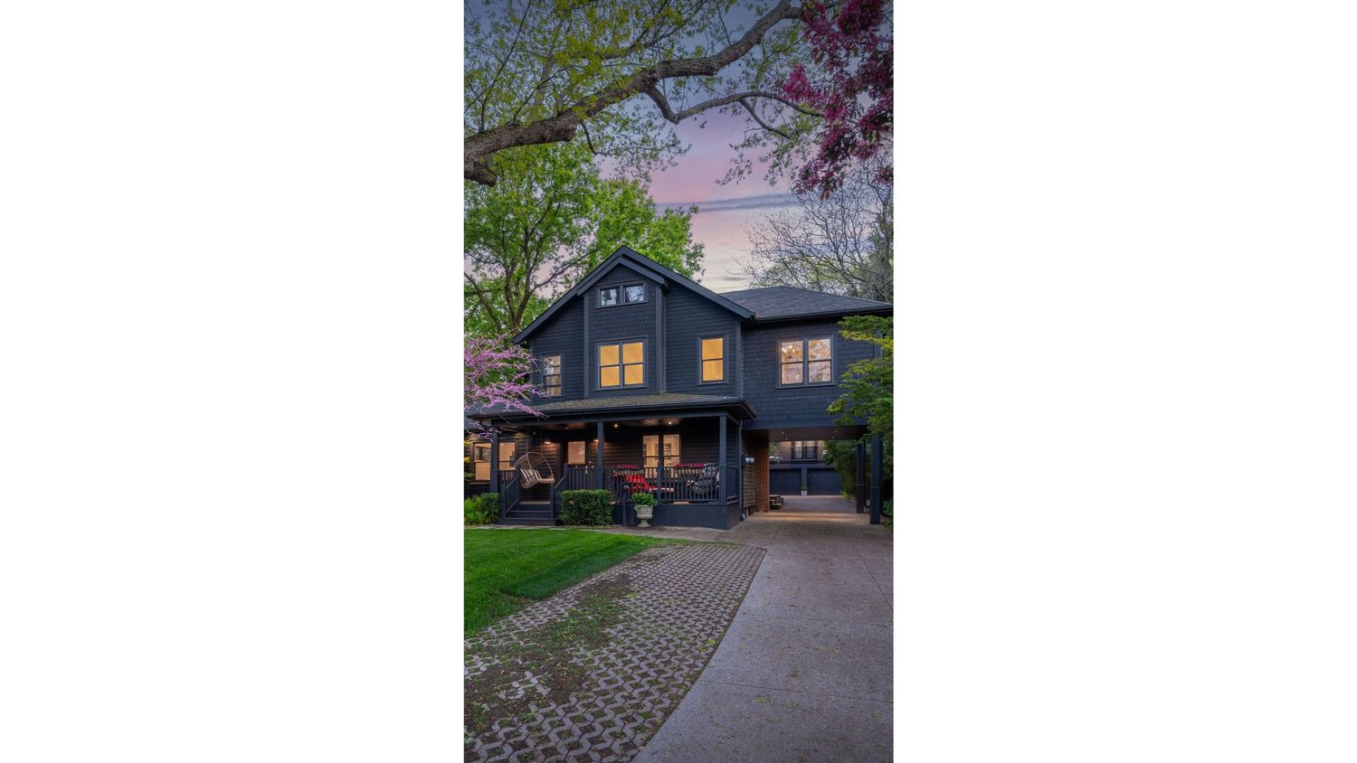 Panoramic view of a modern blue house located at 52 Kerr St, Oakville with blooming cherry trees in the front yard.