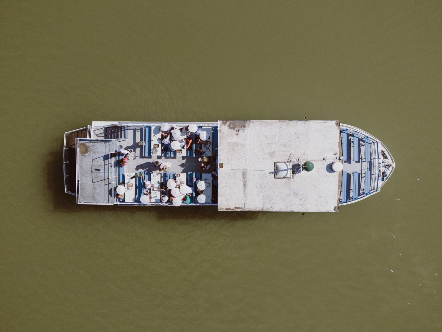Aerial view of cargo ship on muddy river waters seen from above.