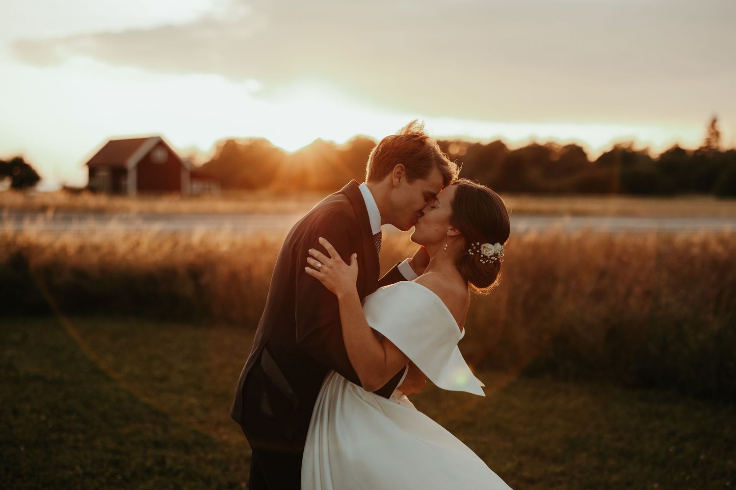 Brudpar kysser varandra passionerat under golden hour på deras bröllop i Näfstad Loge. Foto: Grevholm Photography